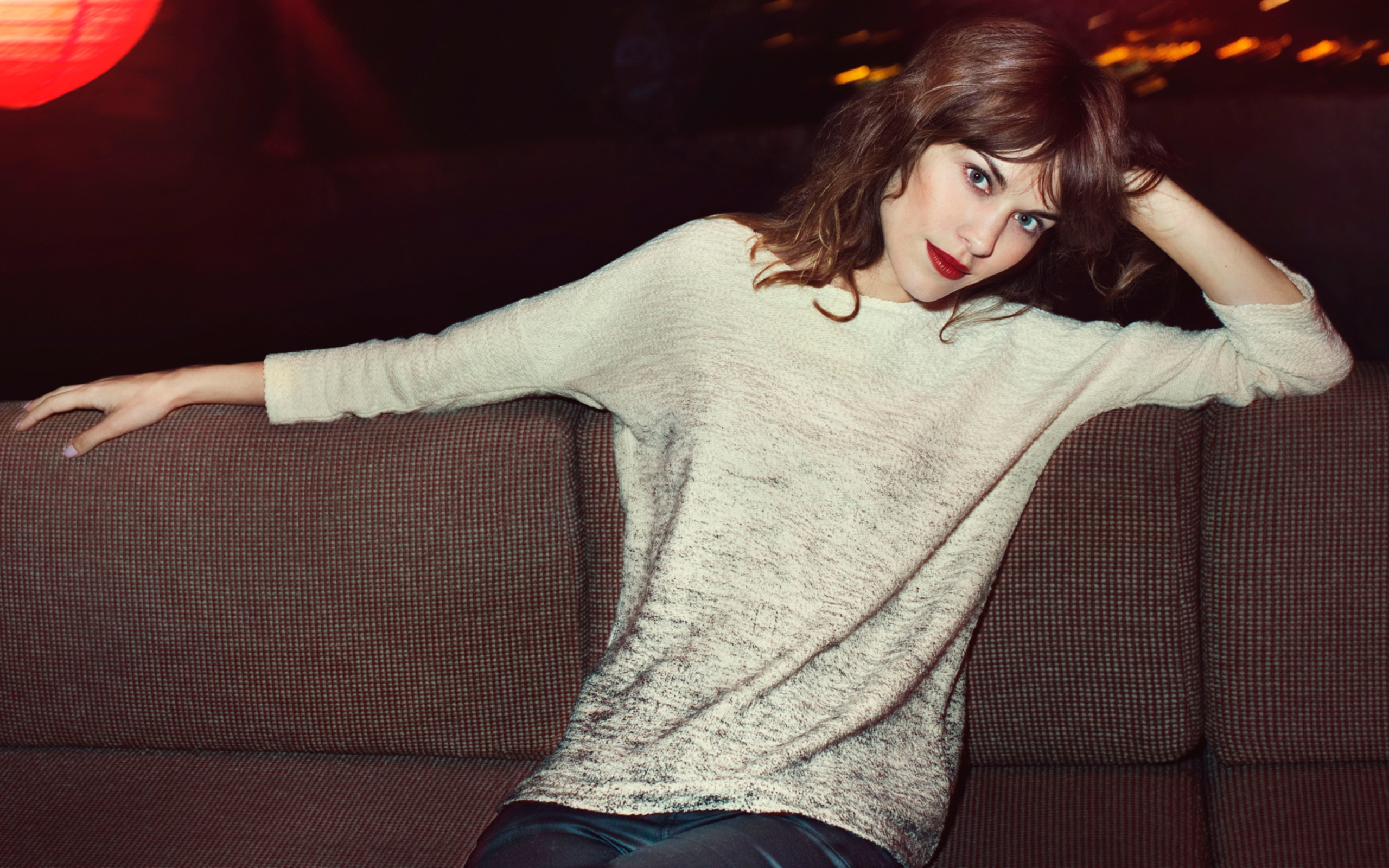 Красивая девушка модель Алекса Чанг сидит на диване