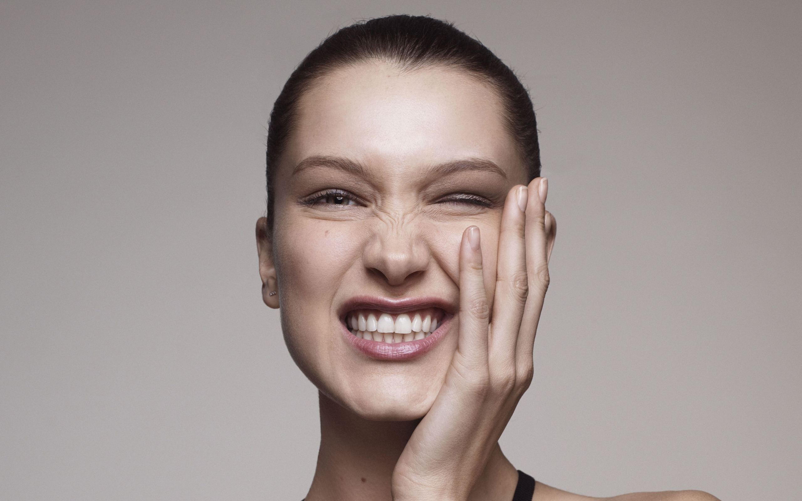 Модель Белла Хадид корчит гримасы на сером фоне