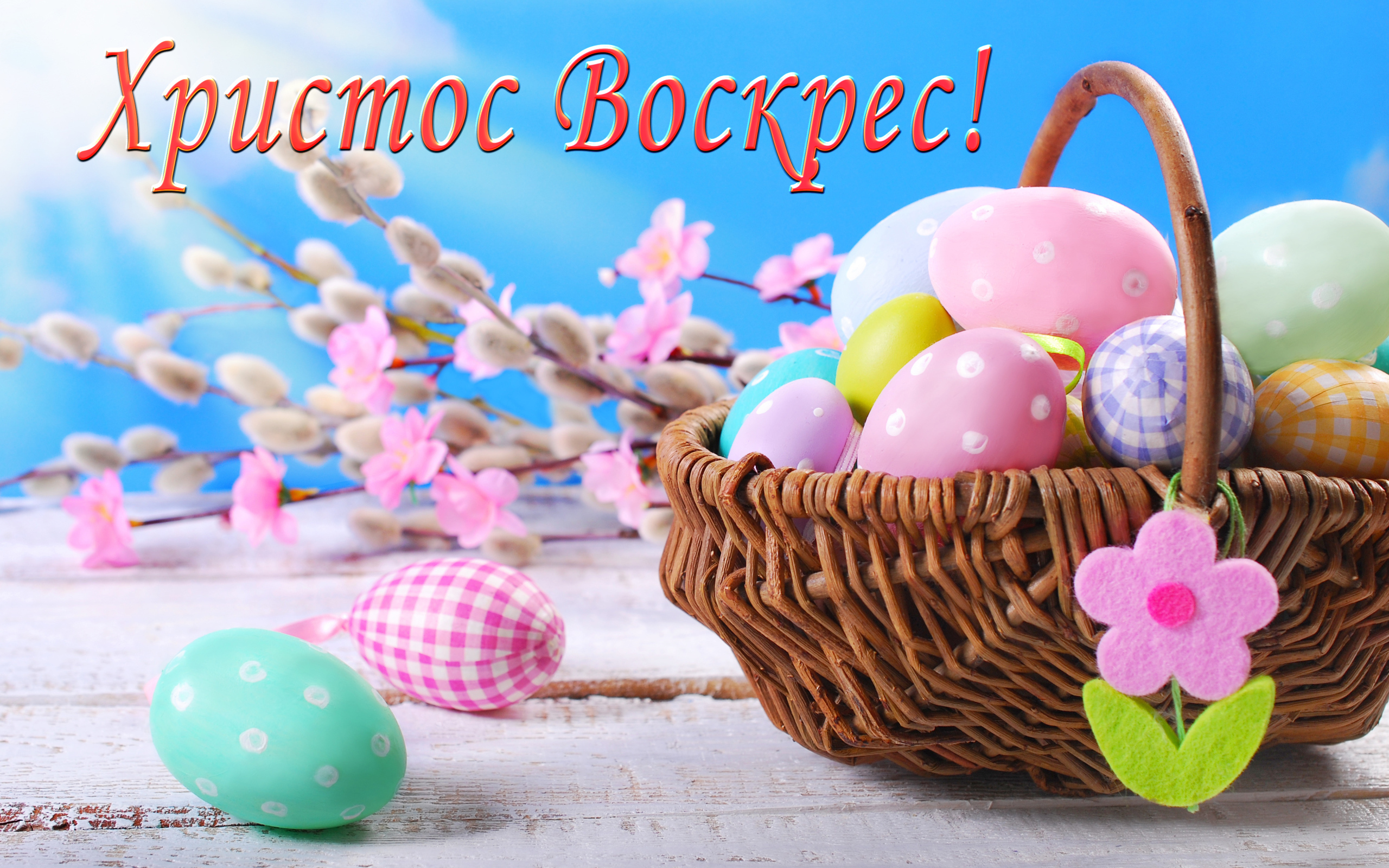 Корзина крашеных яиц на голубом фоне с надписью Христос Воскрес! 