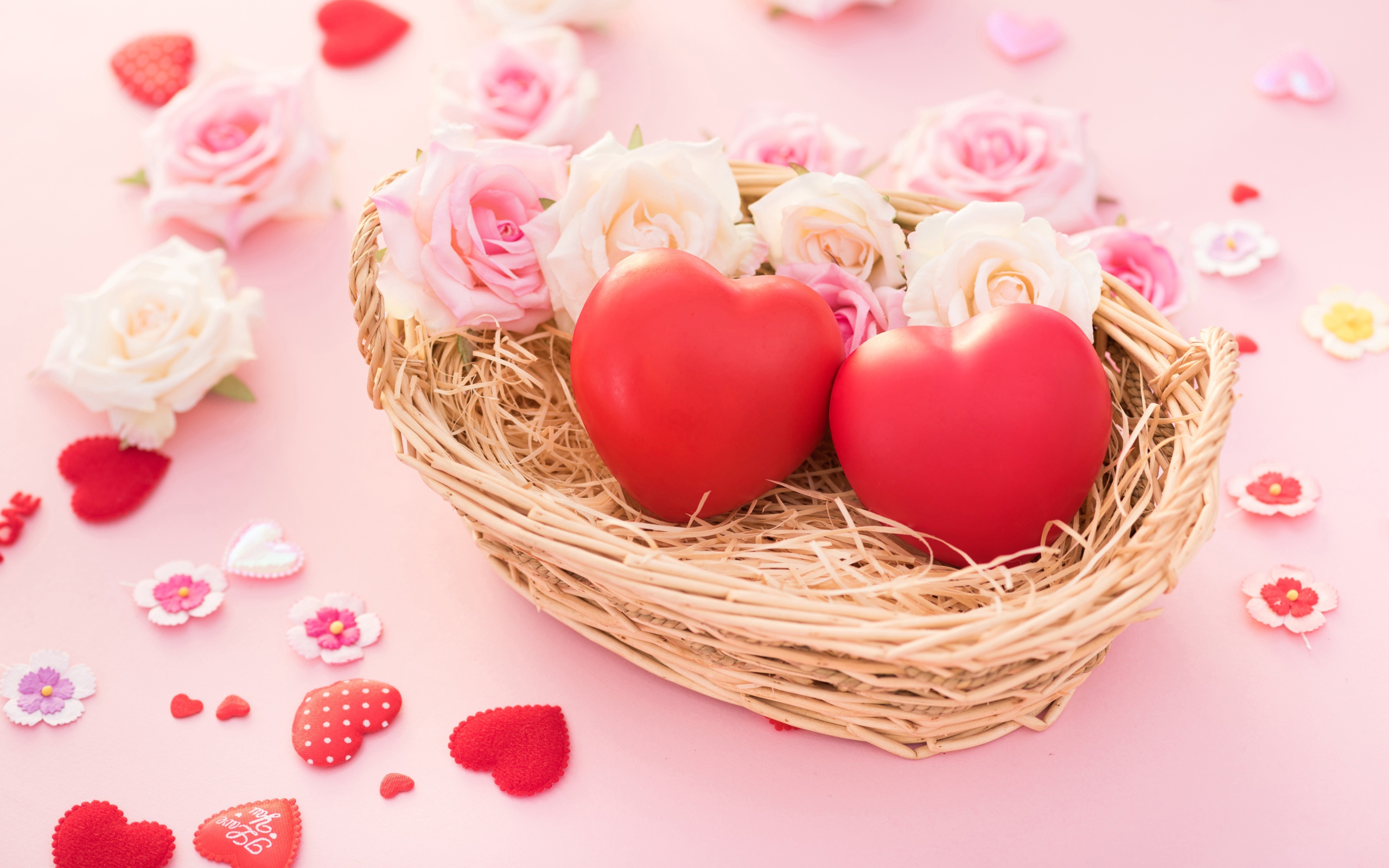 Два красных сердца лежат в корзинке с розами 