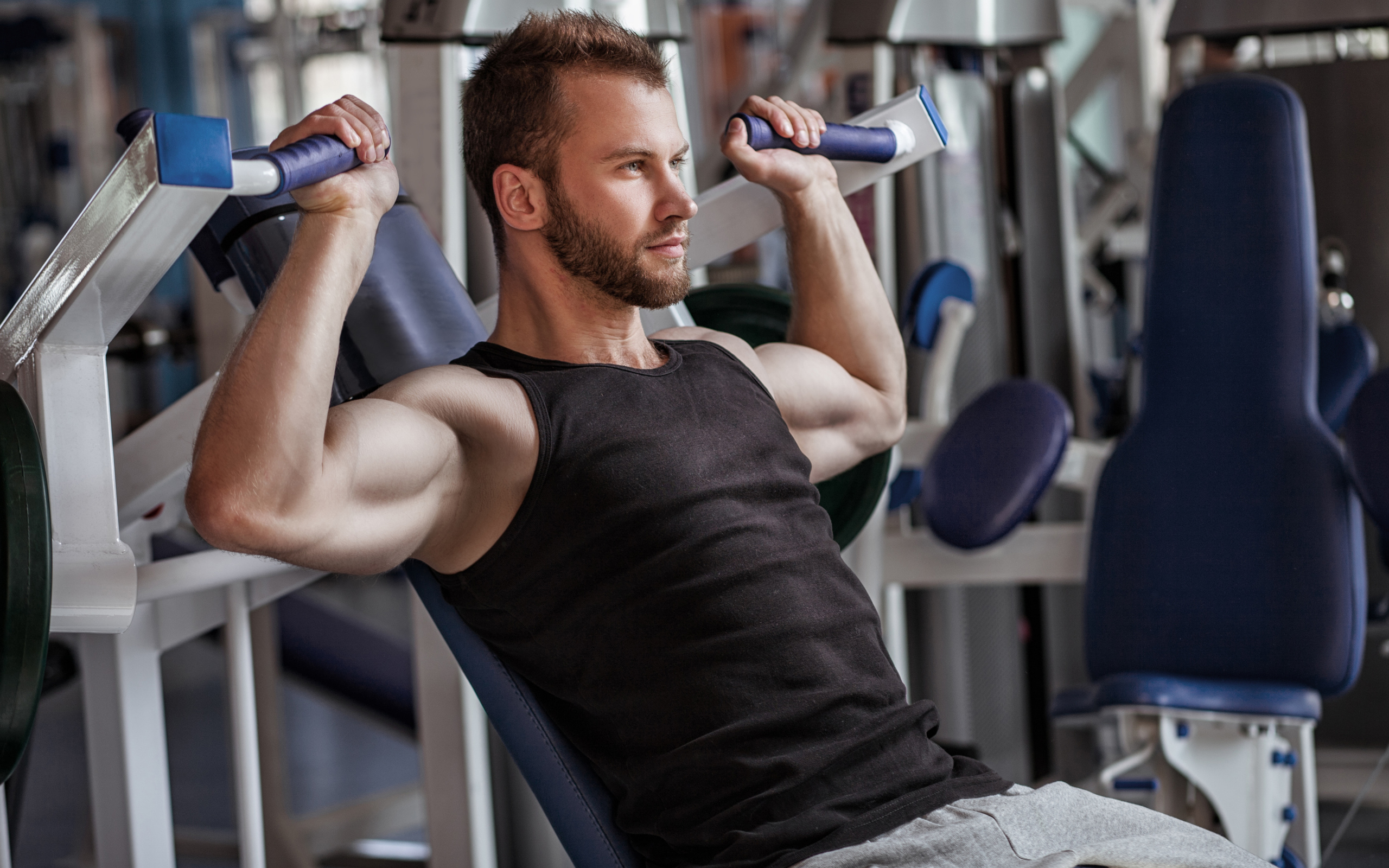 Накаченный мужчина занимается в спортзале