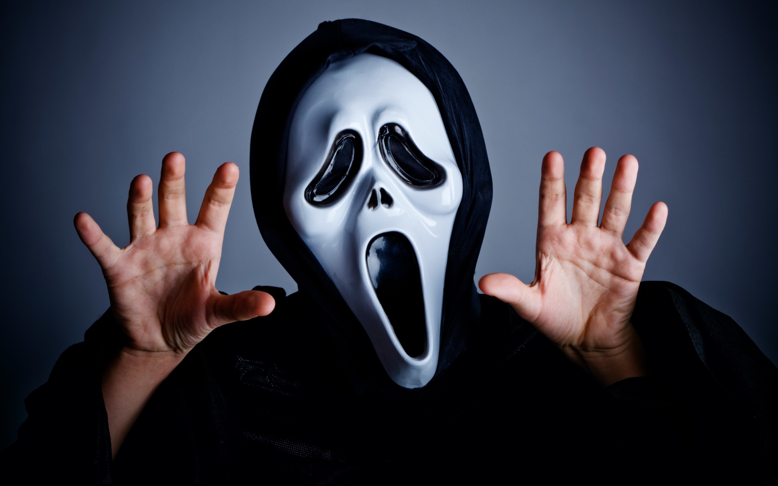 Мужчина в маске пугает на сером фоне