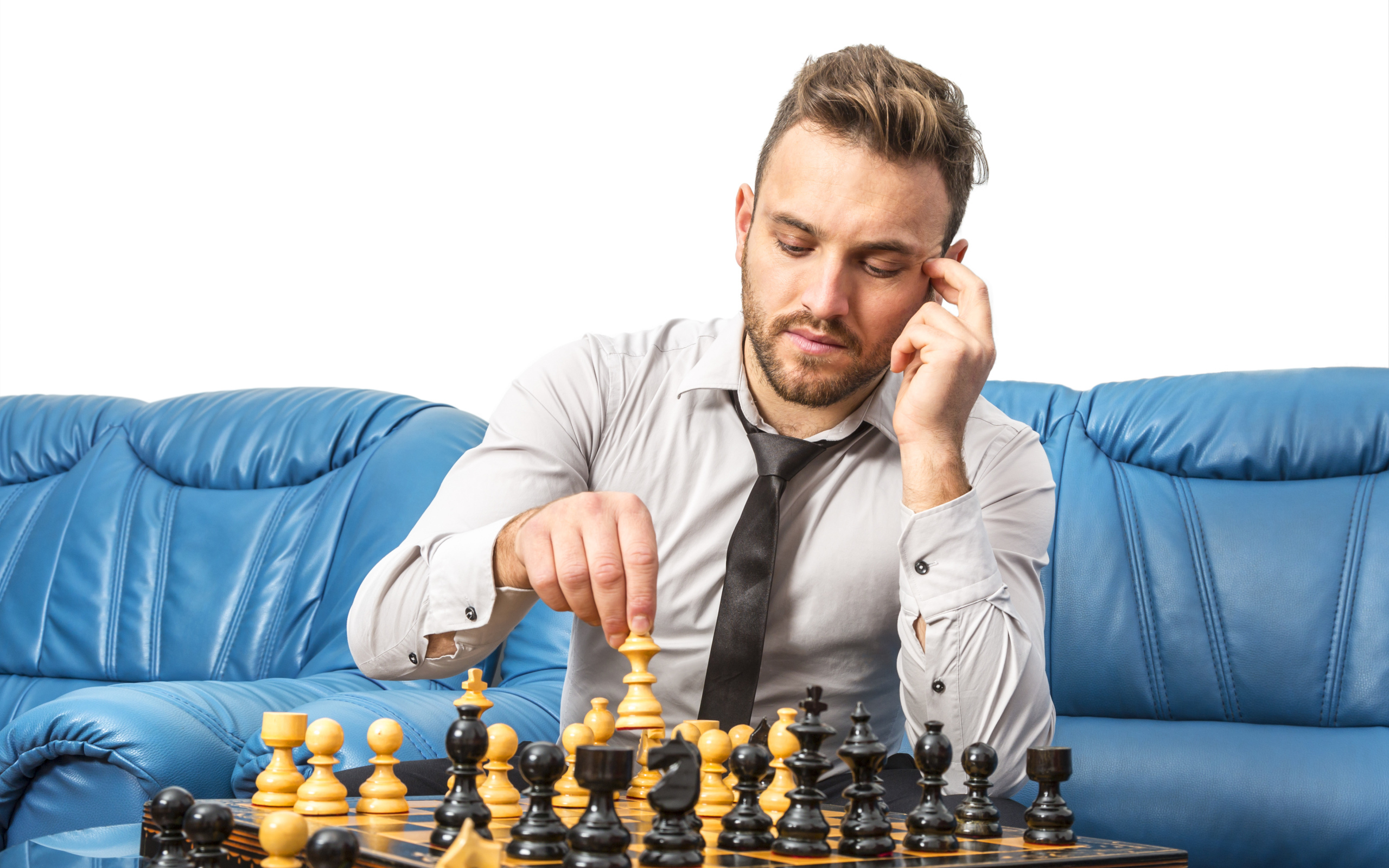 Мужчина играет в шахматы на синем диване