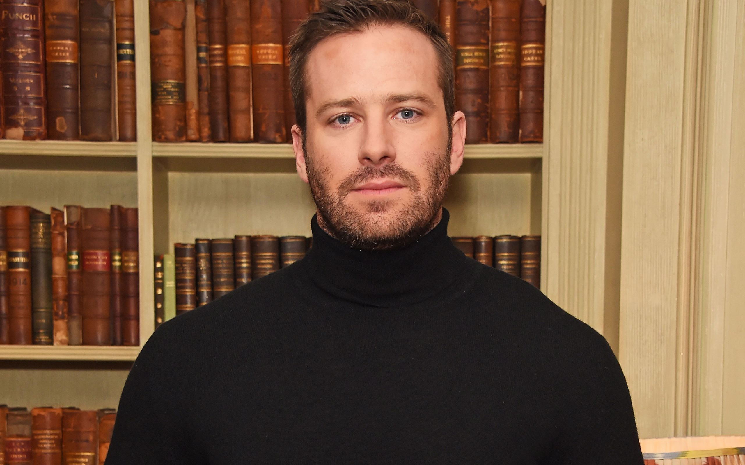 Актер Арми Хаммер стоит у библиотеки