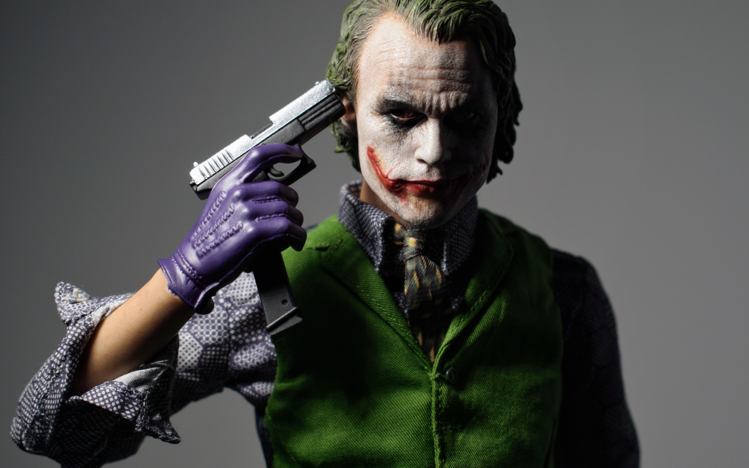 Персонаж Джокер с пистолетом в руке на сером фоне