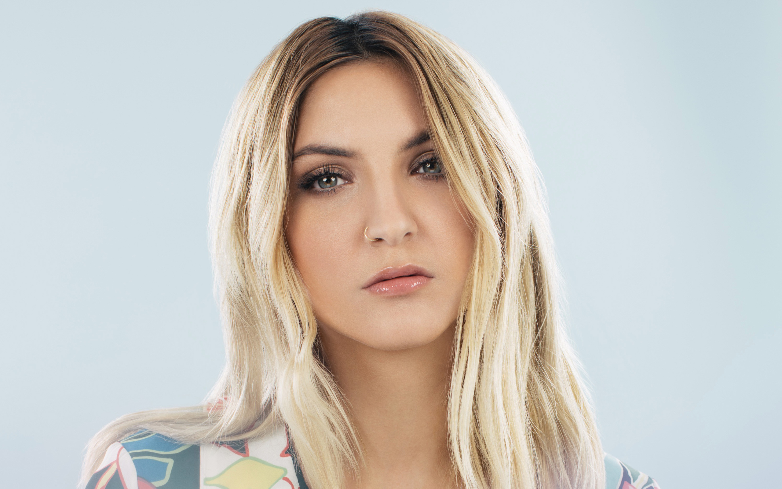 Красивая блондинка, певица Джулия Майклз на сером фоне