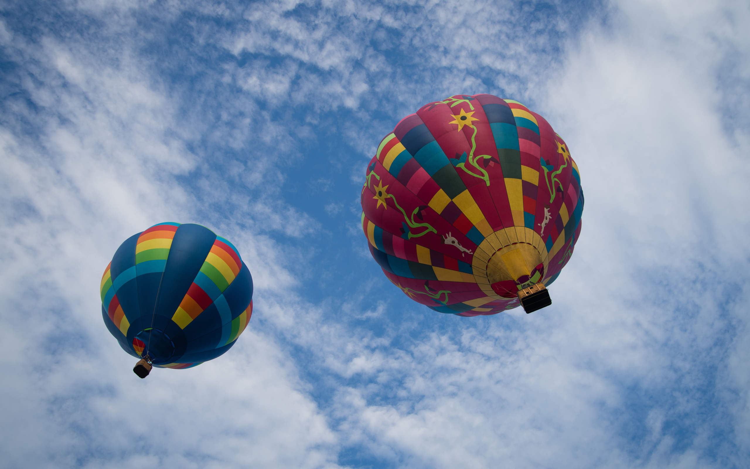 Два больших воздушных шара в голубом небе с белыми облаками