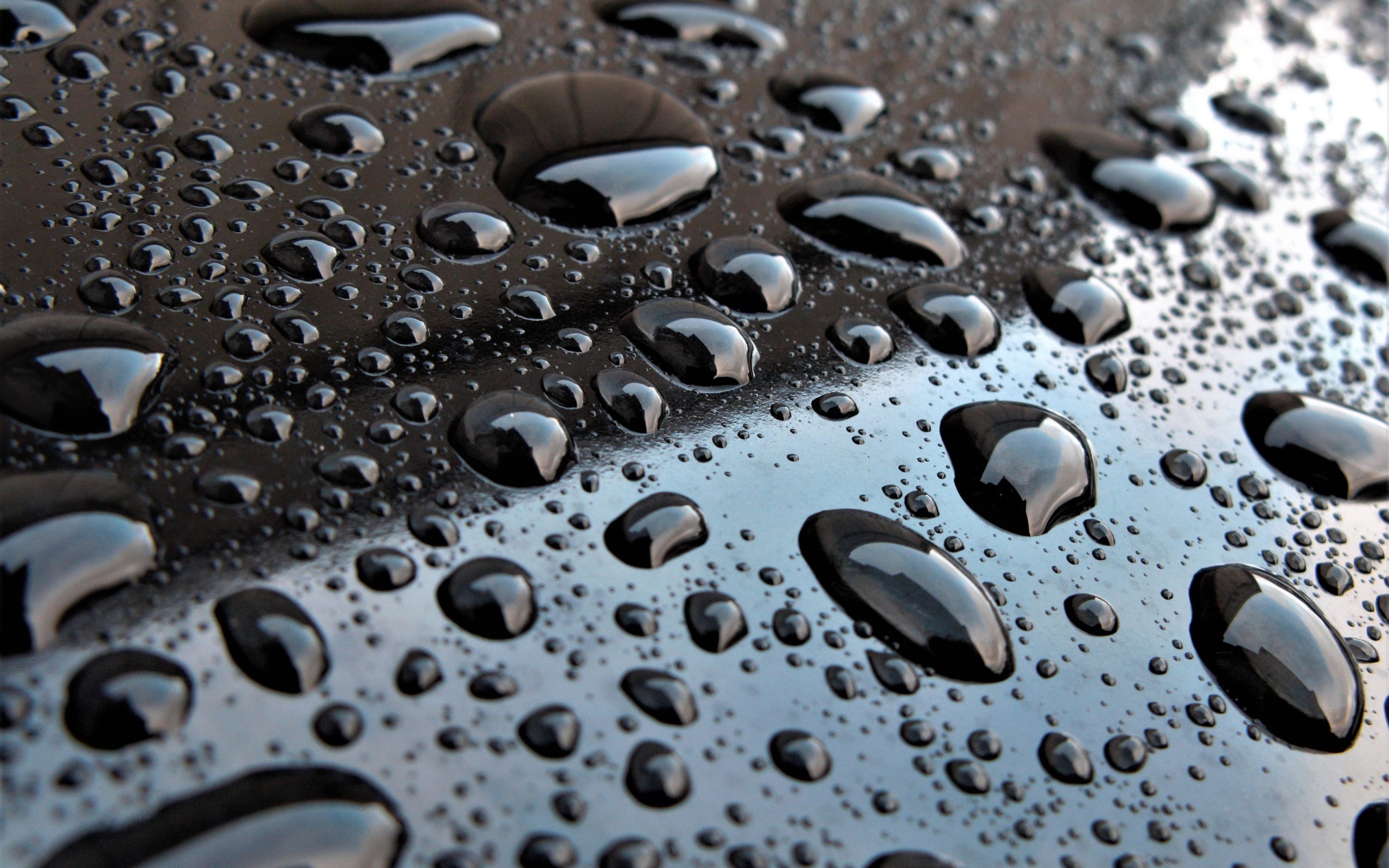 Капли воды на черной глянцевой поверхности 