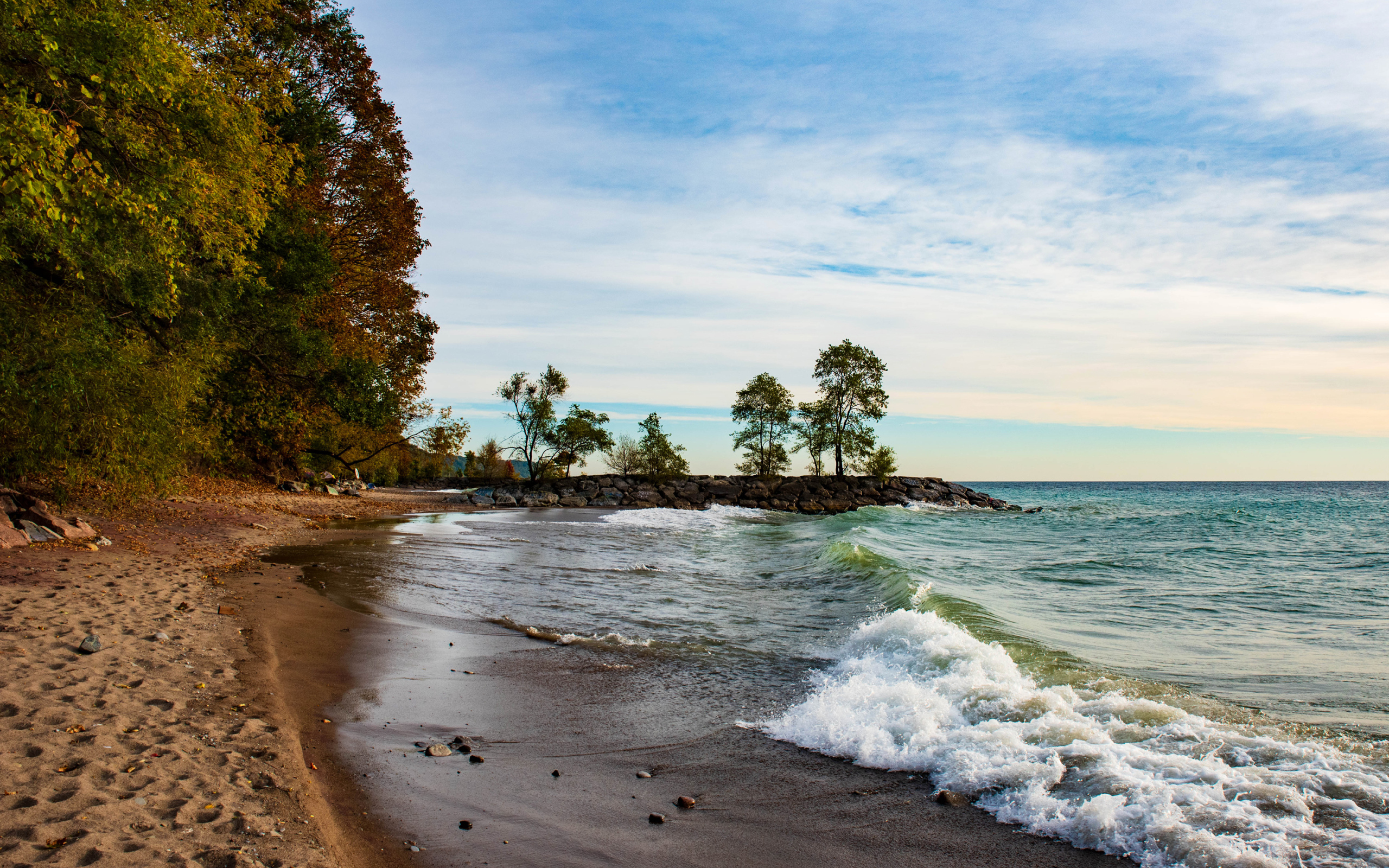 Белые волны океана на мокром песке под красивым небом