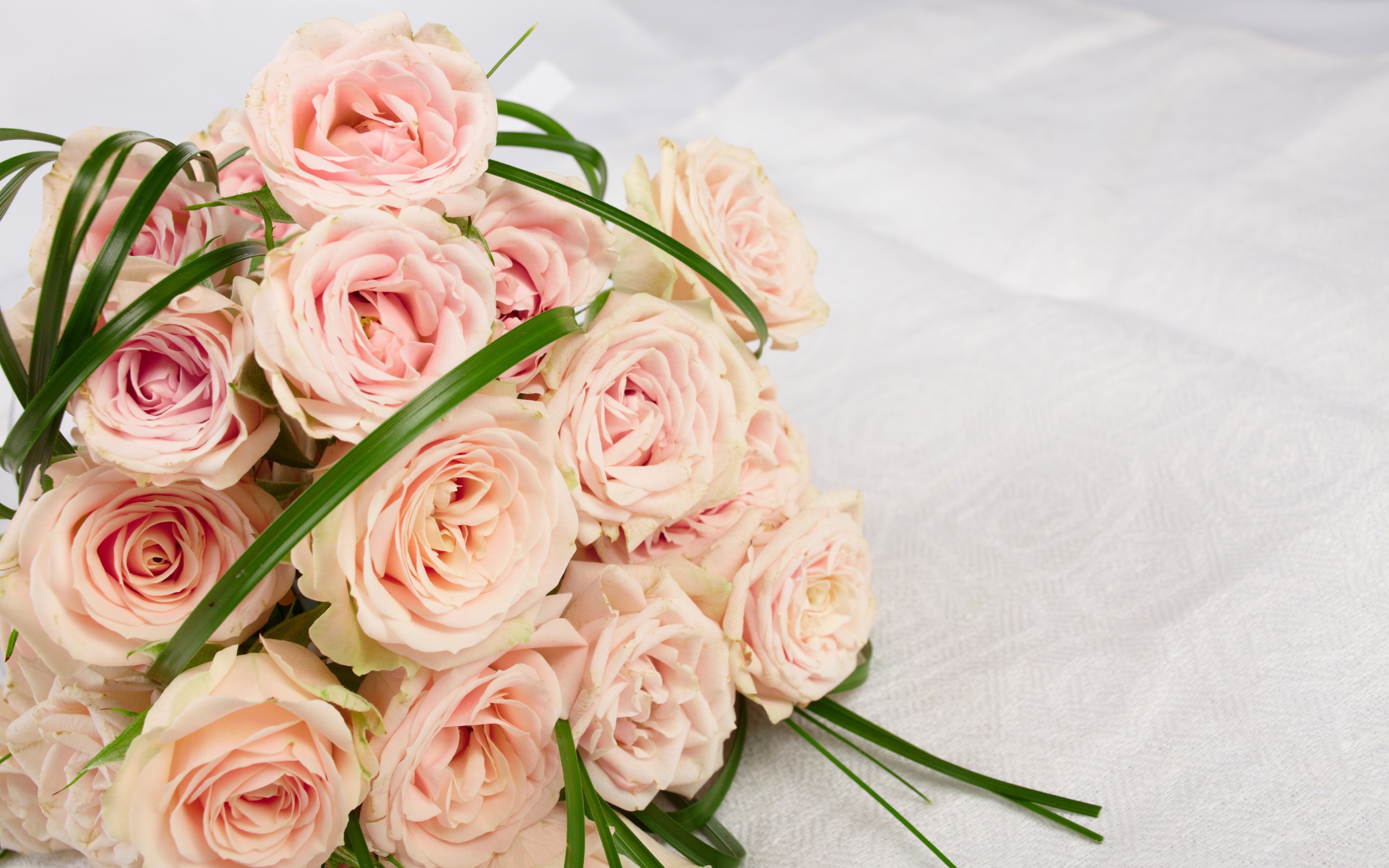 Букет розовых роз на белом покрывале 