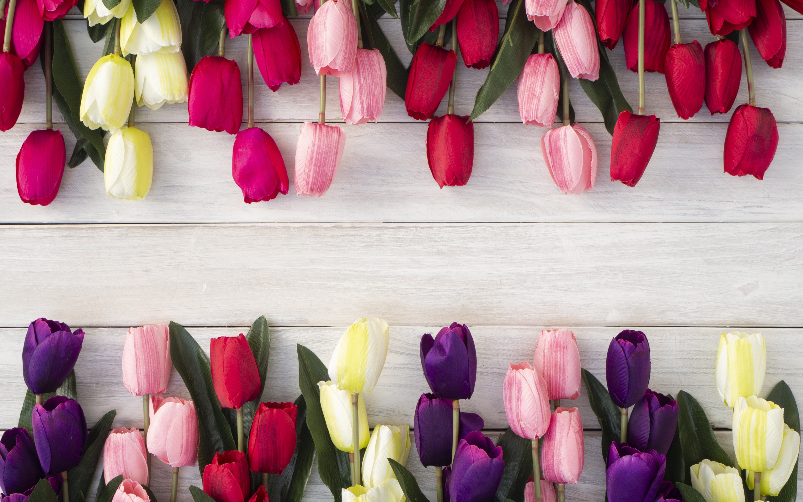 Искусственные разноцветные тюльпаны на деревянной поверхности