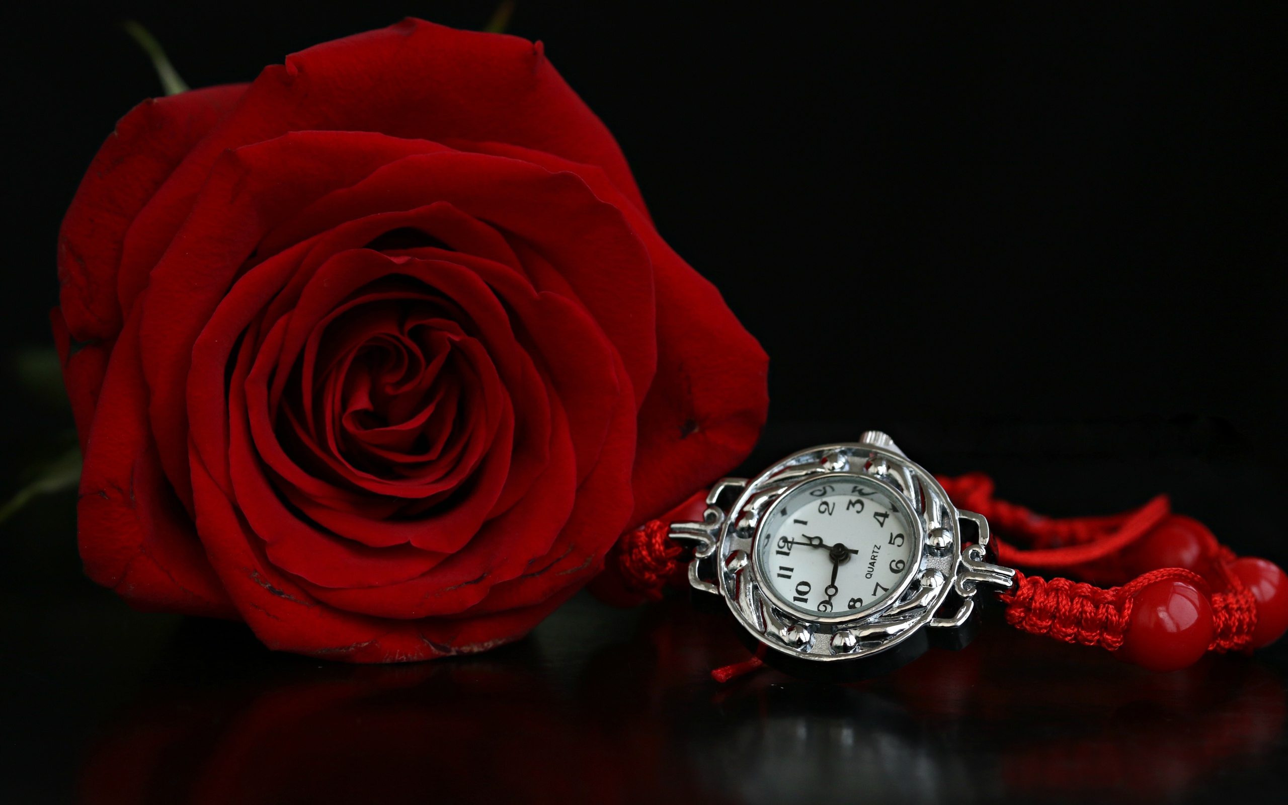 Красная роза с часами на черном фоне