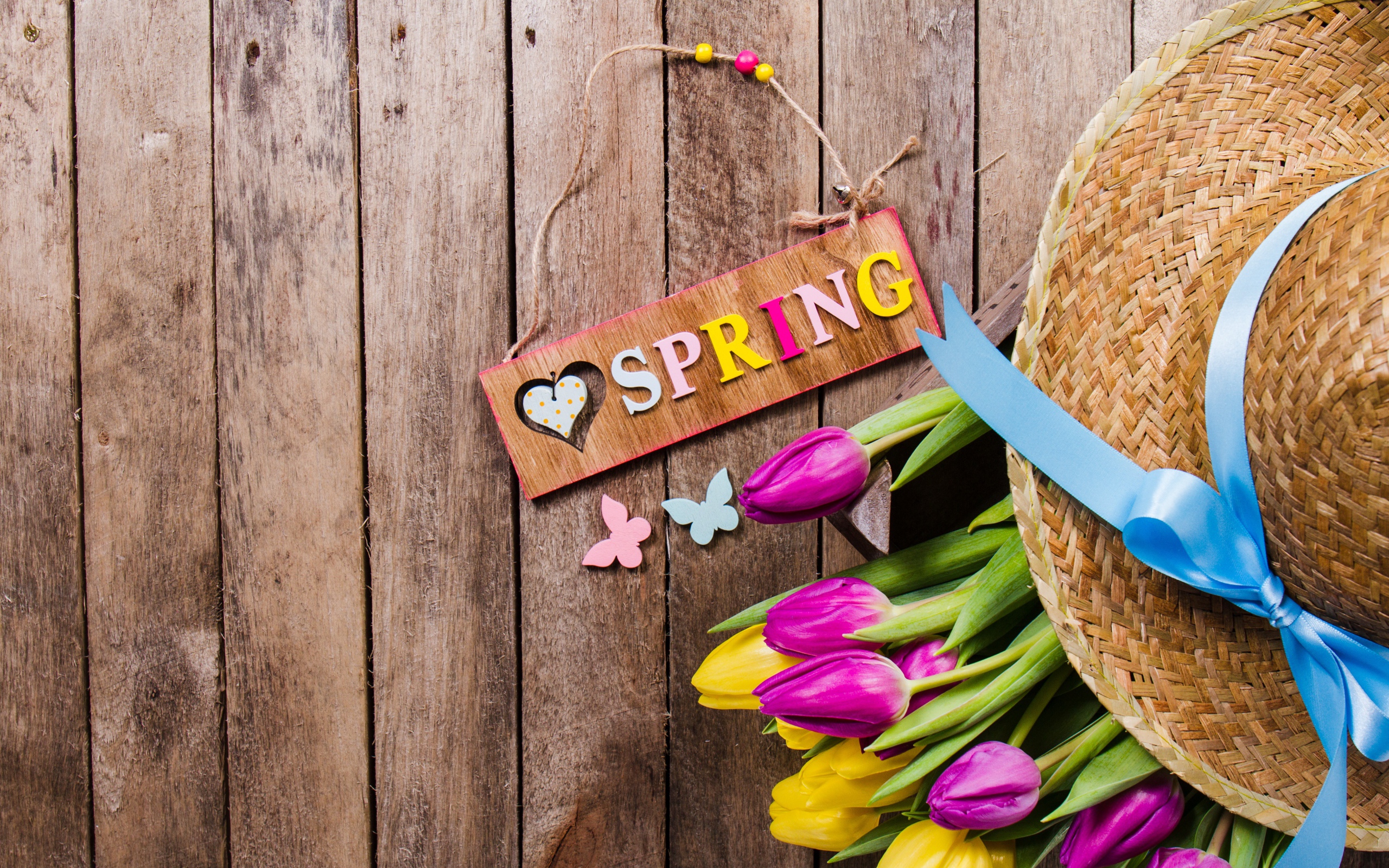 Надпись на английском весна на столе с букетом тюльпанов и шляпой