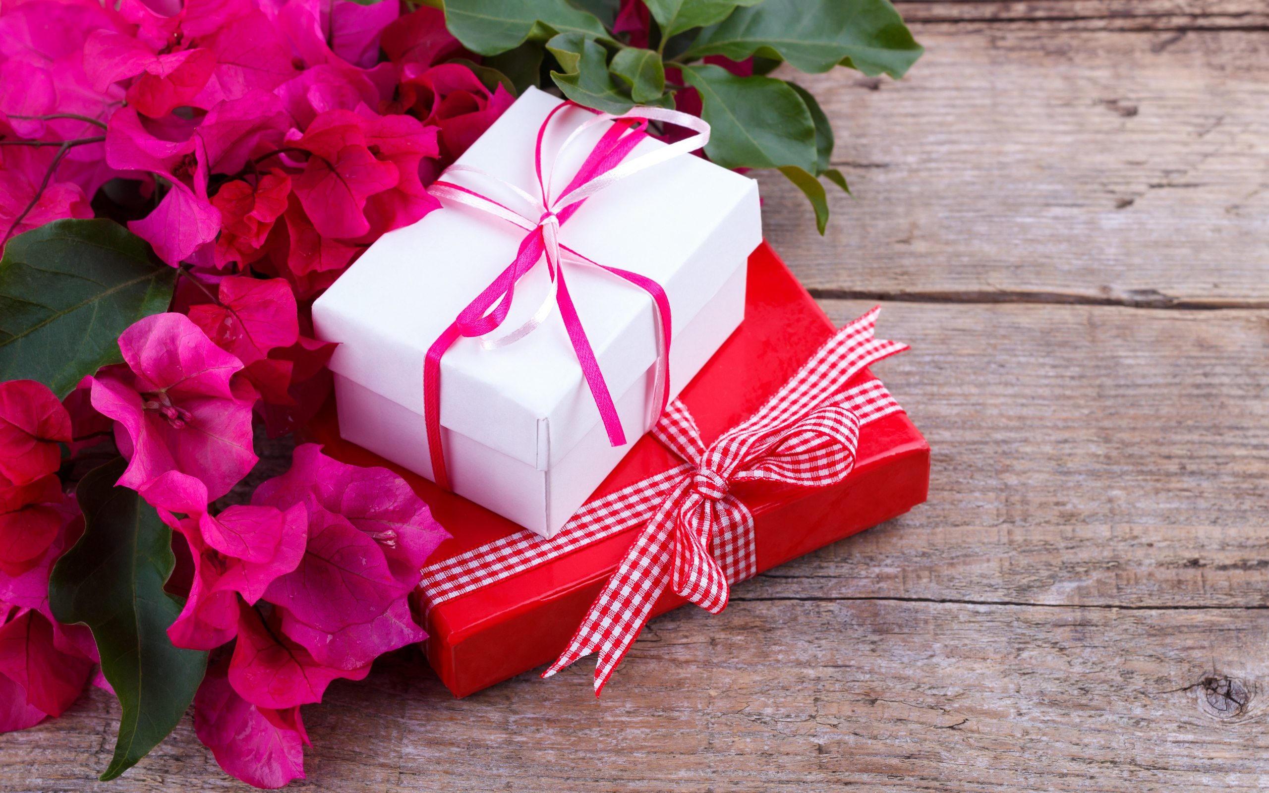Две коробки с подарками на столе с цветами