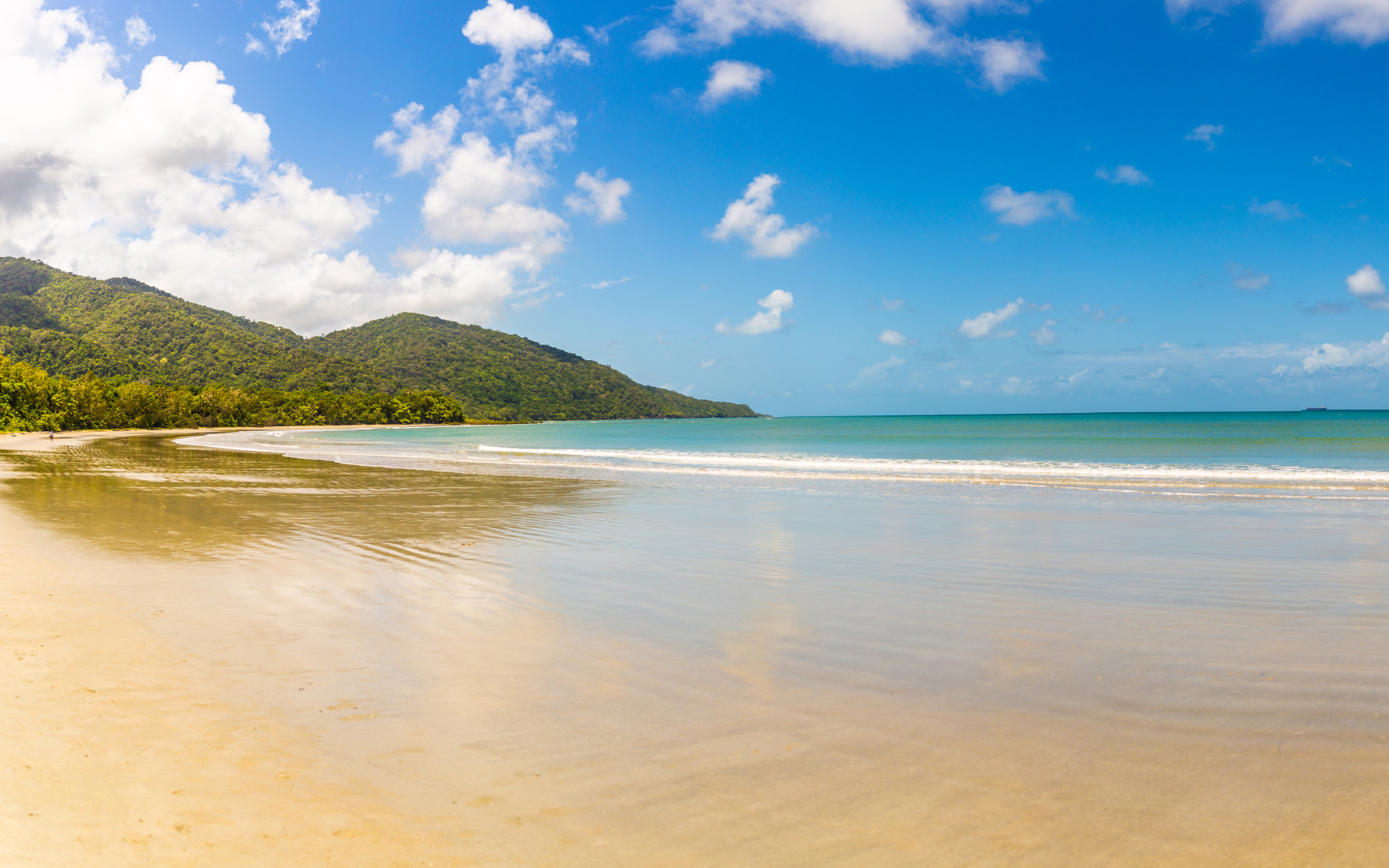 Спокойные волны на песке под красивым голубым небом