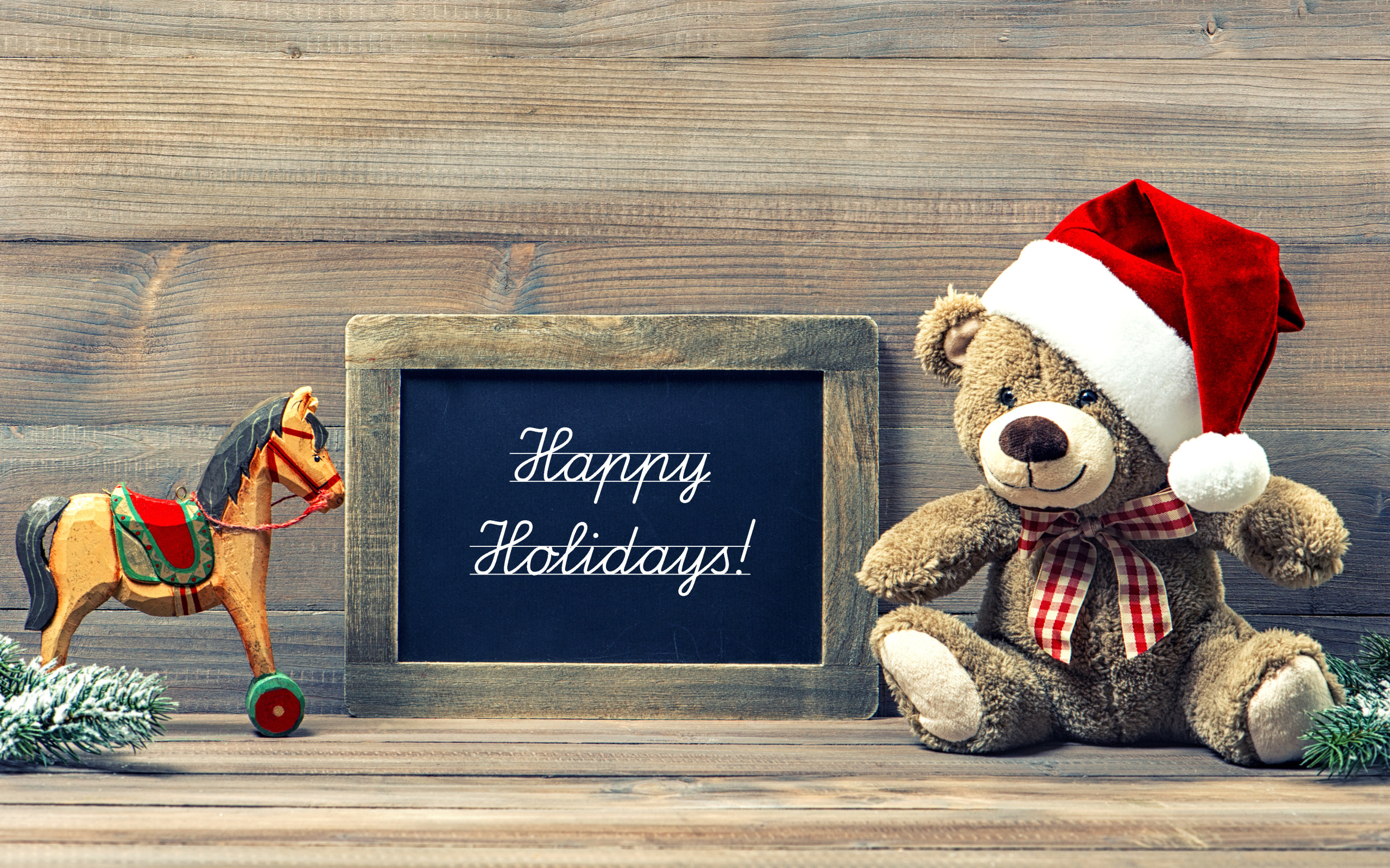 Игрушечный медвежонок Тедди в новогоднем колпаке на деревянном фоне с рамкой