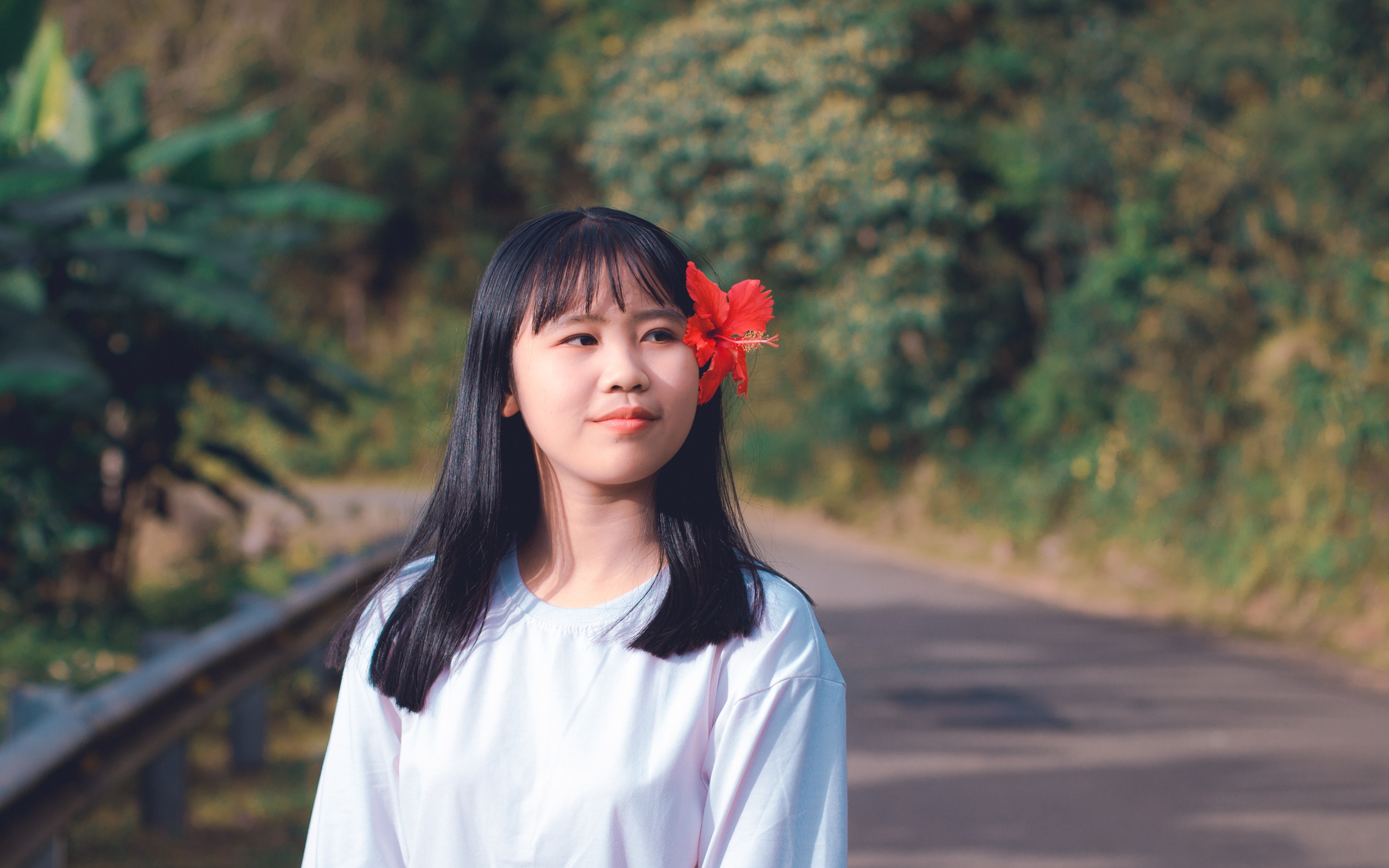 Девушка азиатка с красным цветком гибискуса в волосах