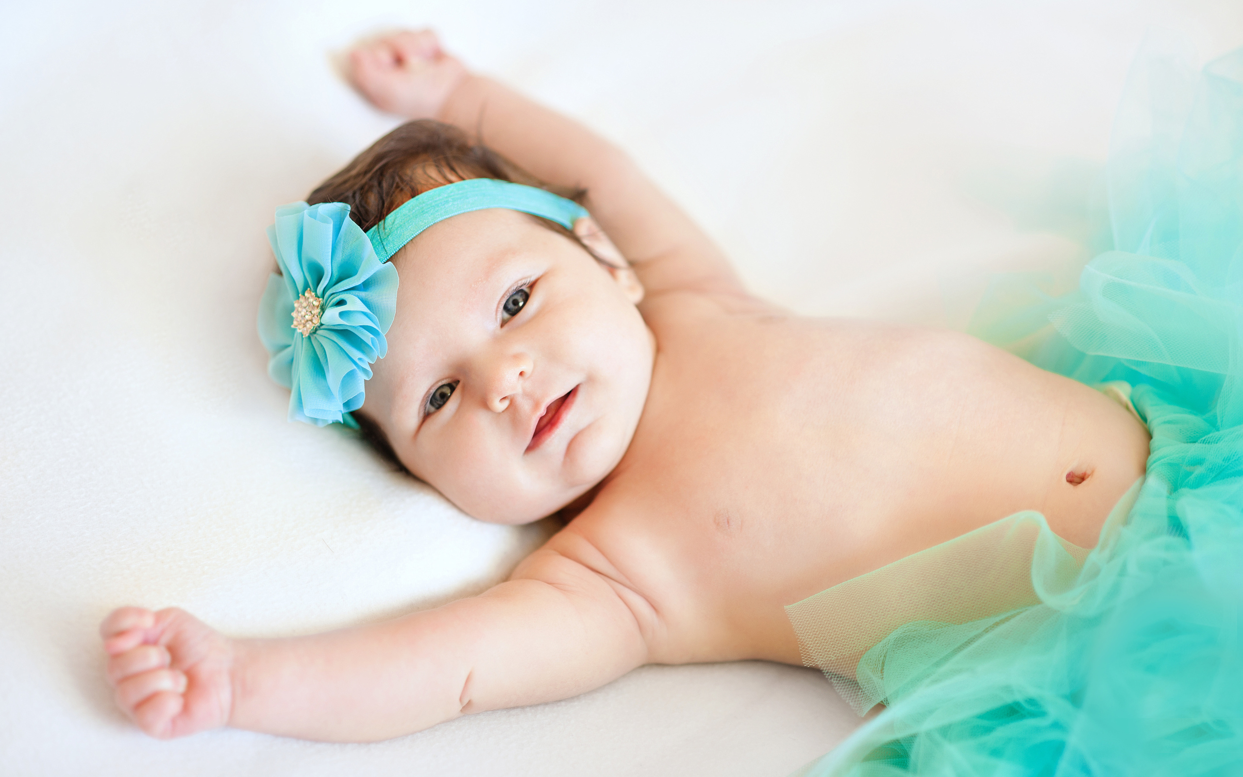 Милая маленькая девочка с повязкой с голубым цветком