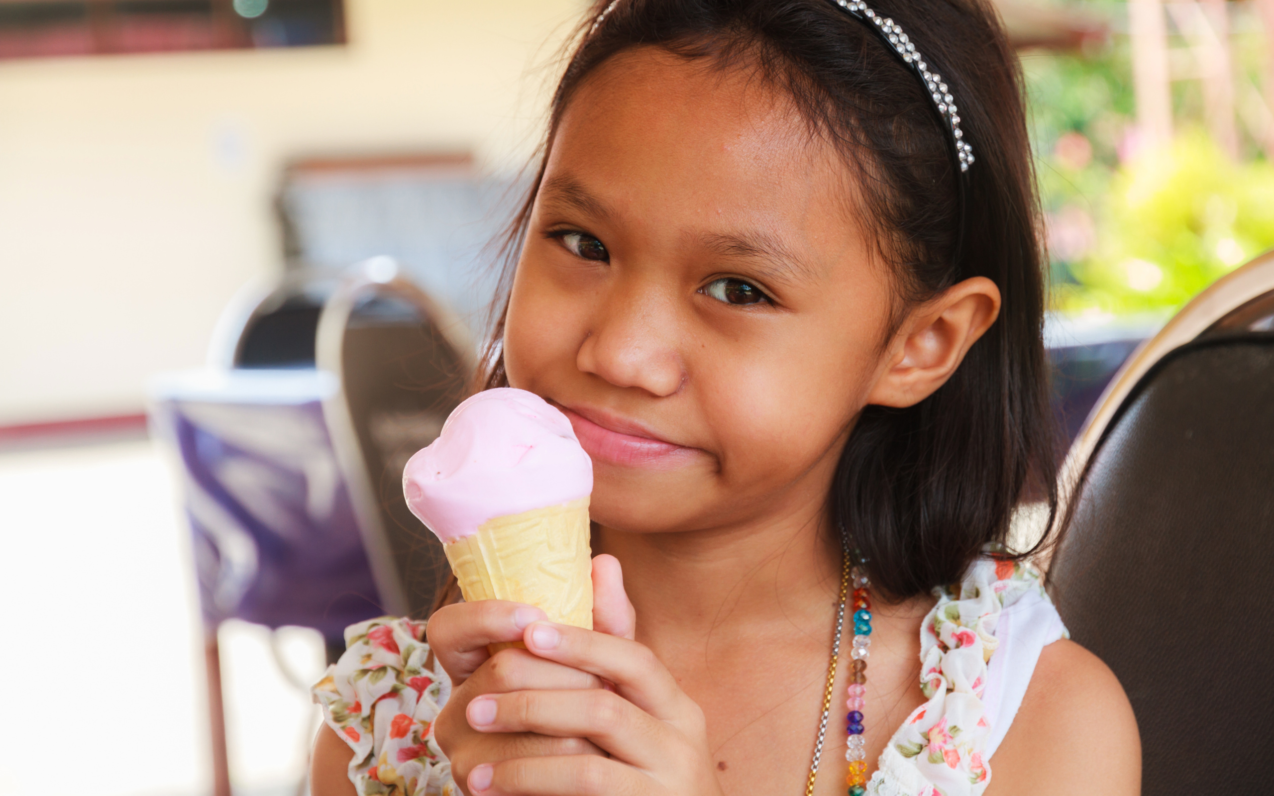 Маленькая девочка азиатка с мороженым в руке