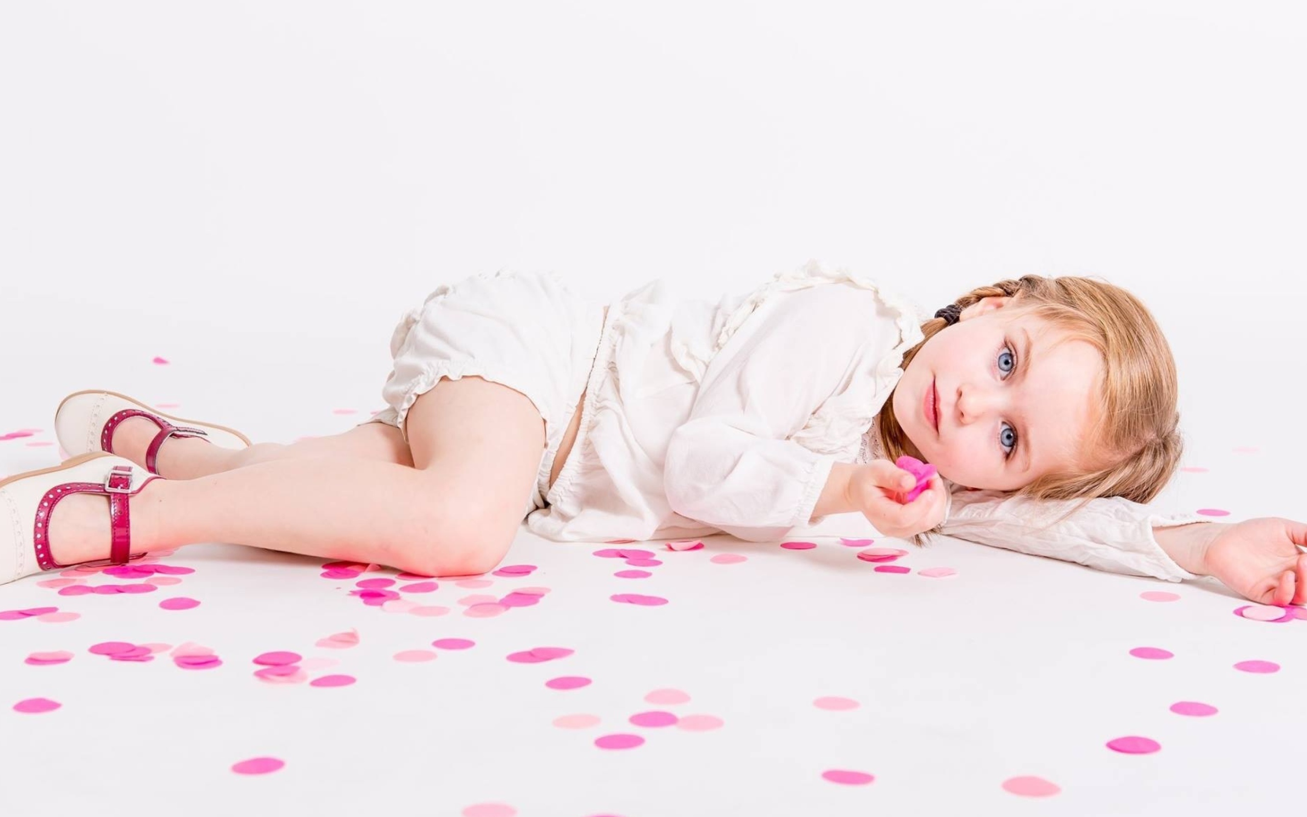 Маленькая голубоглазая девочка лежит на полу