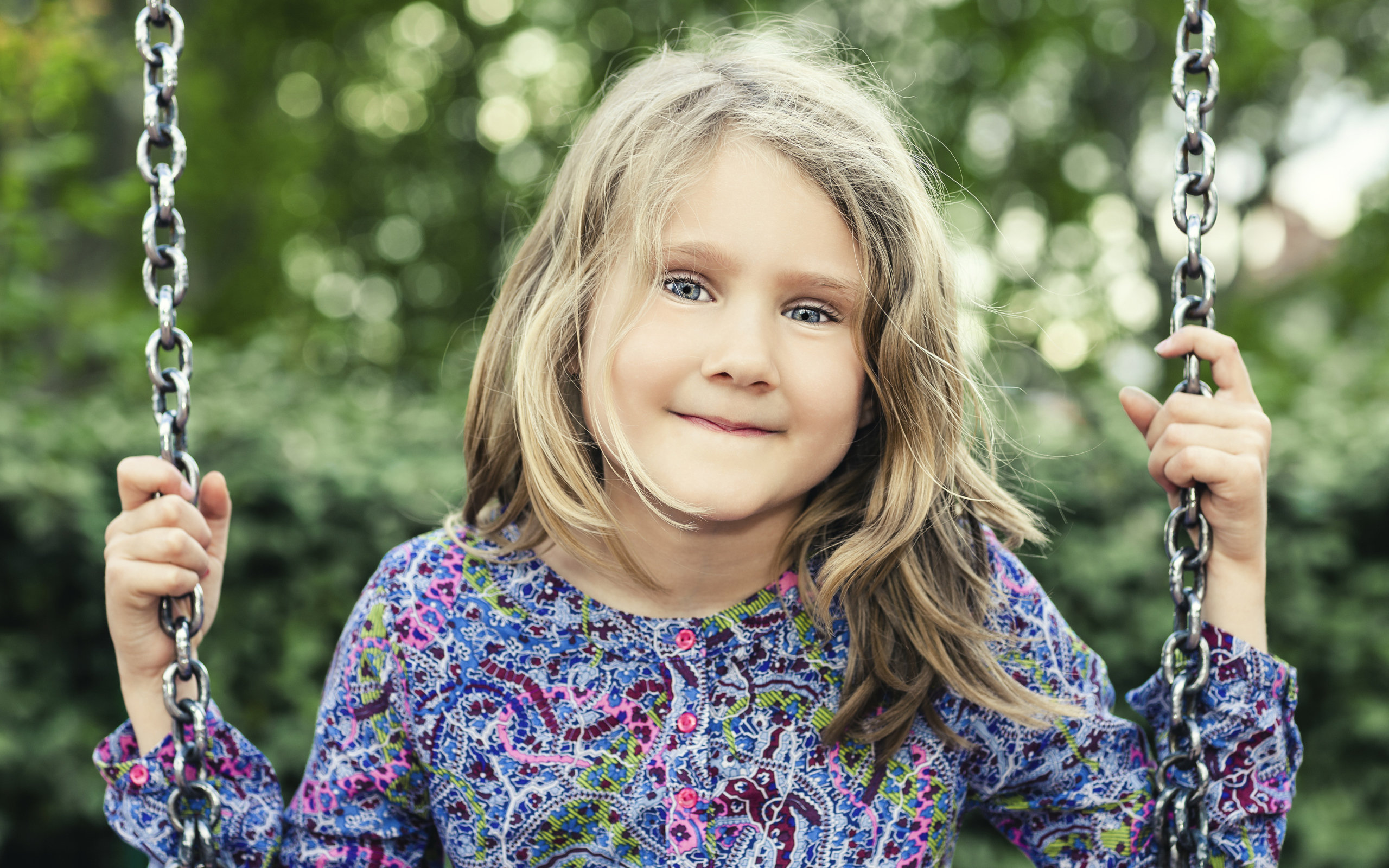 Маленькая милая голубоглазая девочка на качели