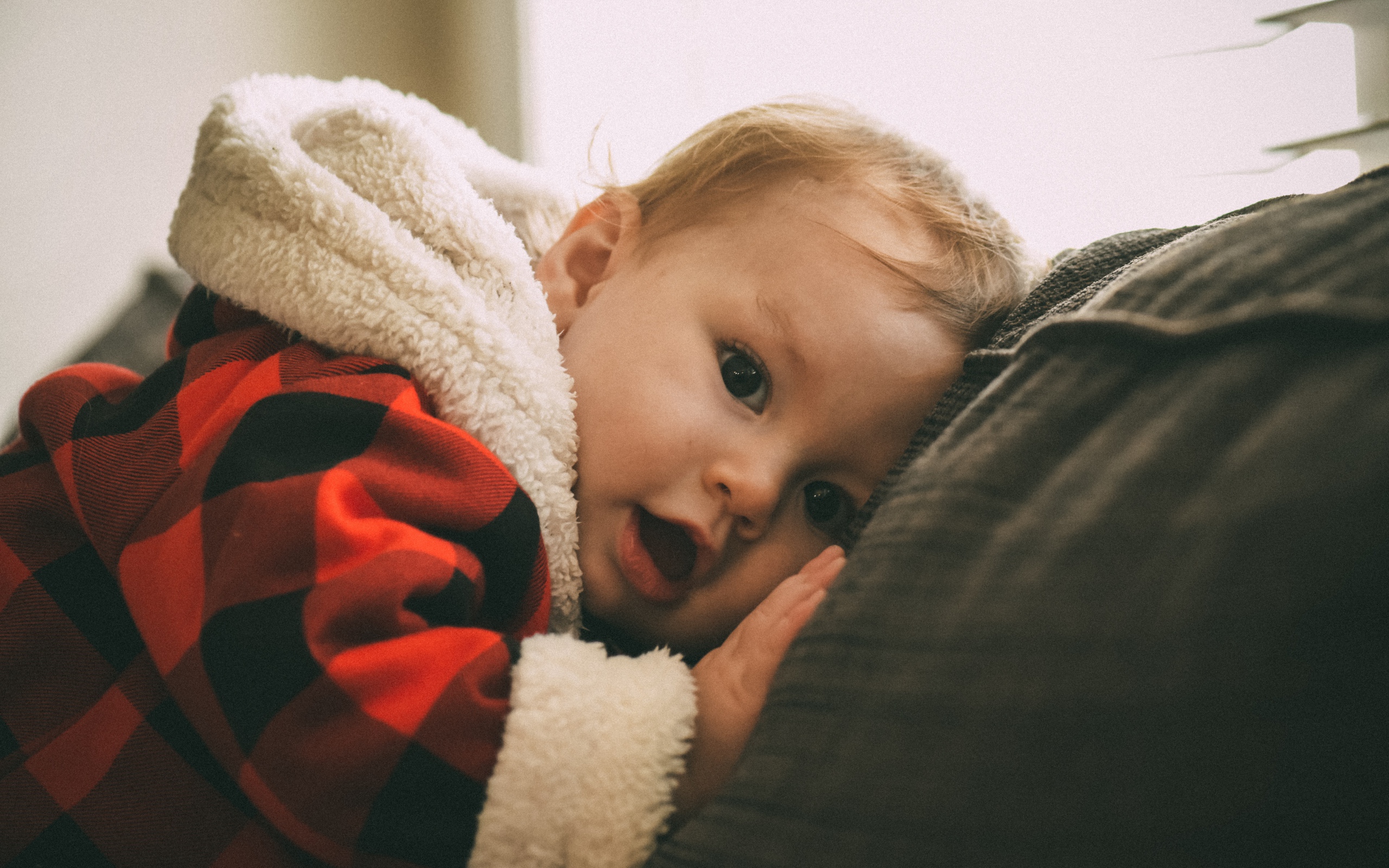 Маленький забавный малыш лежит на диване