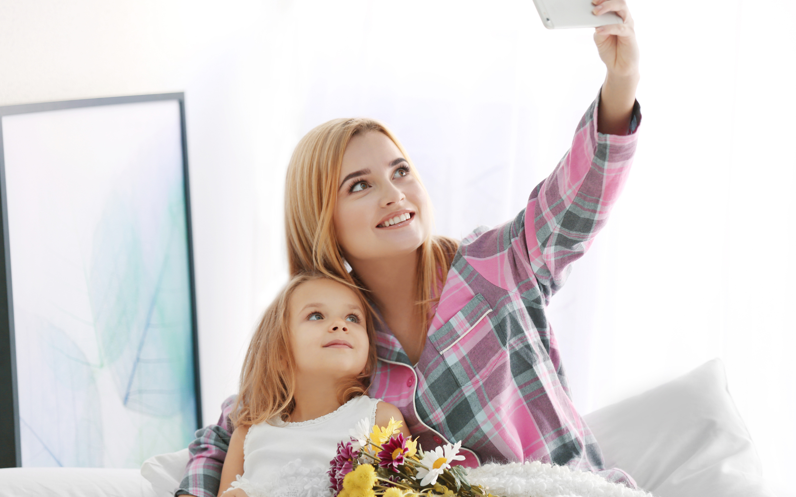 Маленькая девочка с мамой делают фото на смартфон