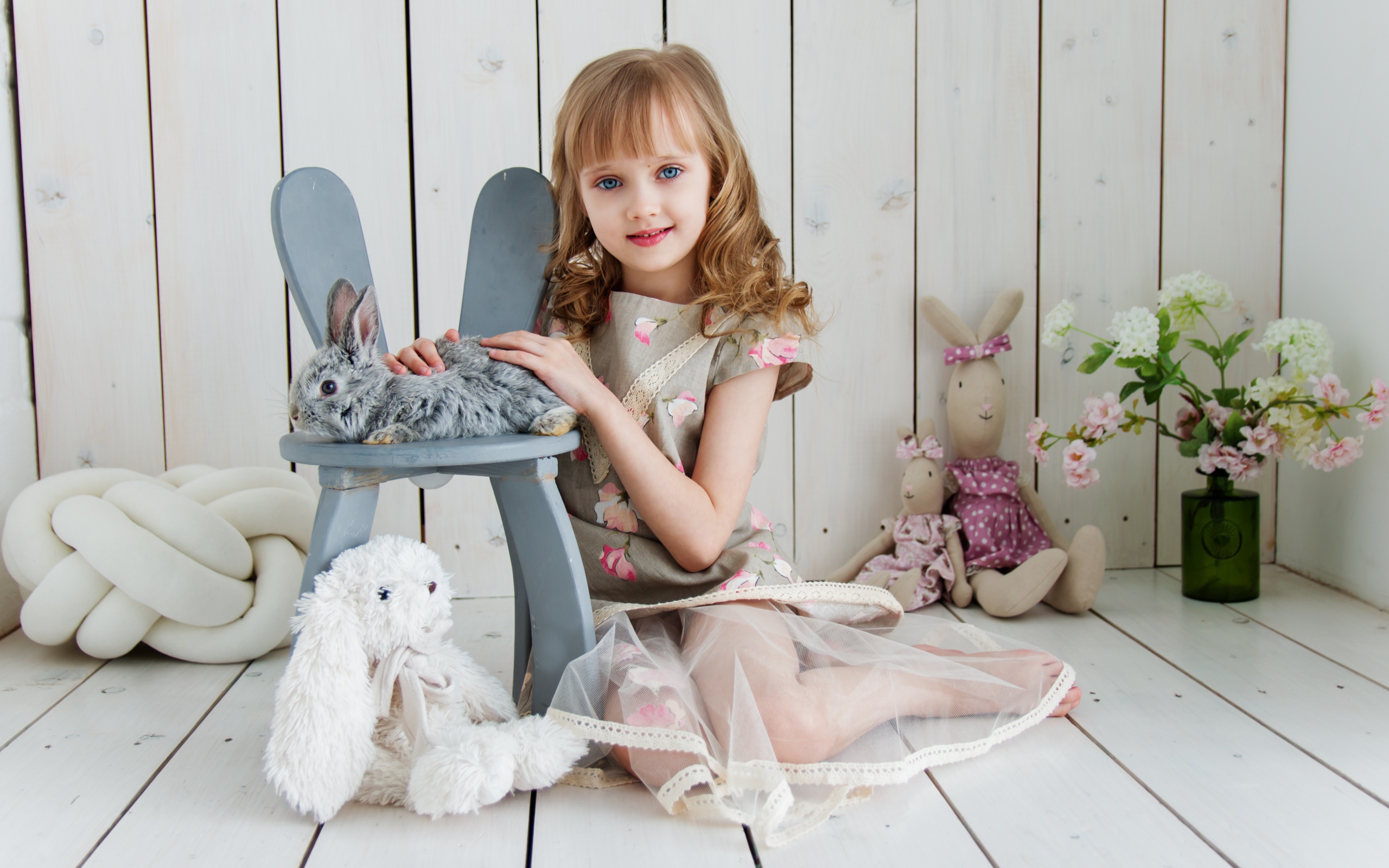 Маленькая девочка с игрушками в комнате сидит на полу