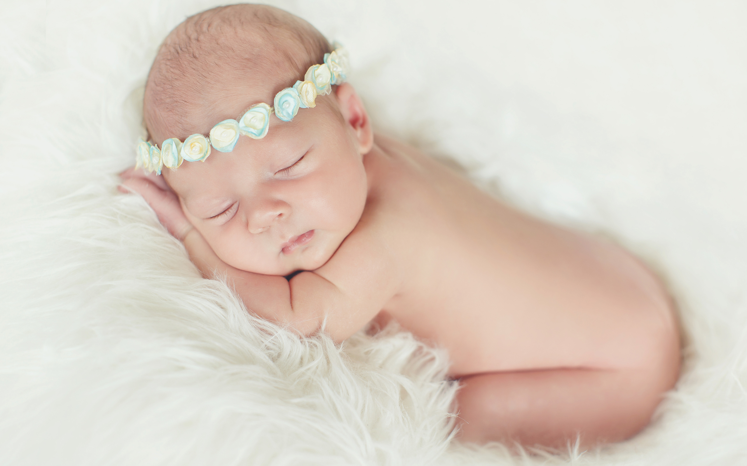 Маленький спящий ребенок на меховом покрывале