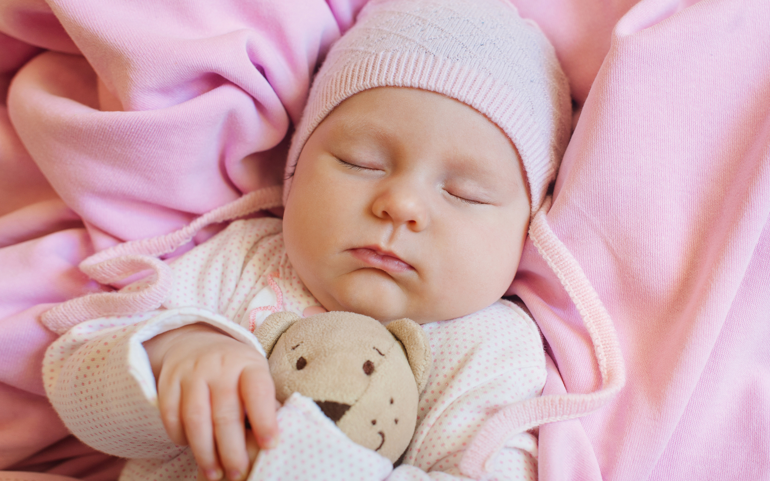 Спящий ребенок обнимает любимую игрушку