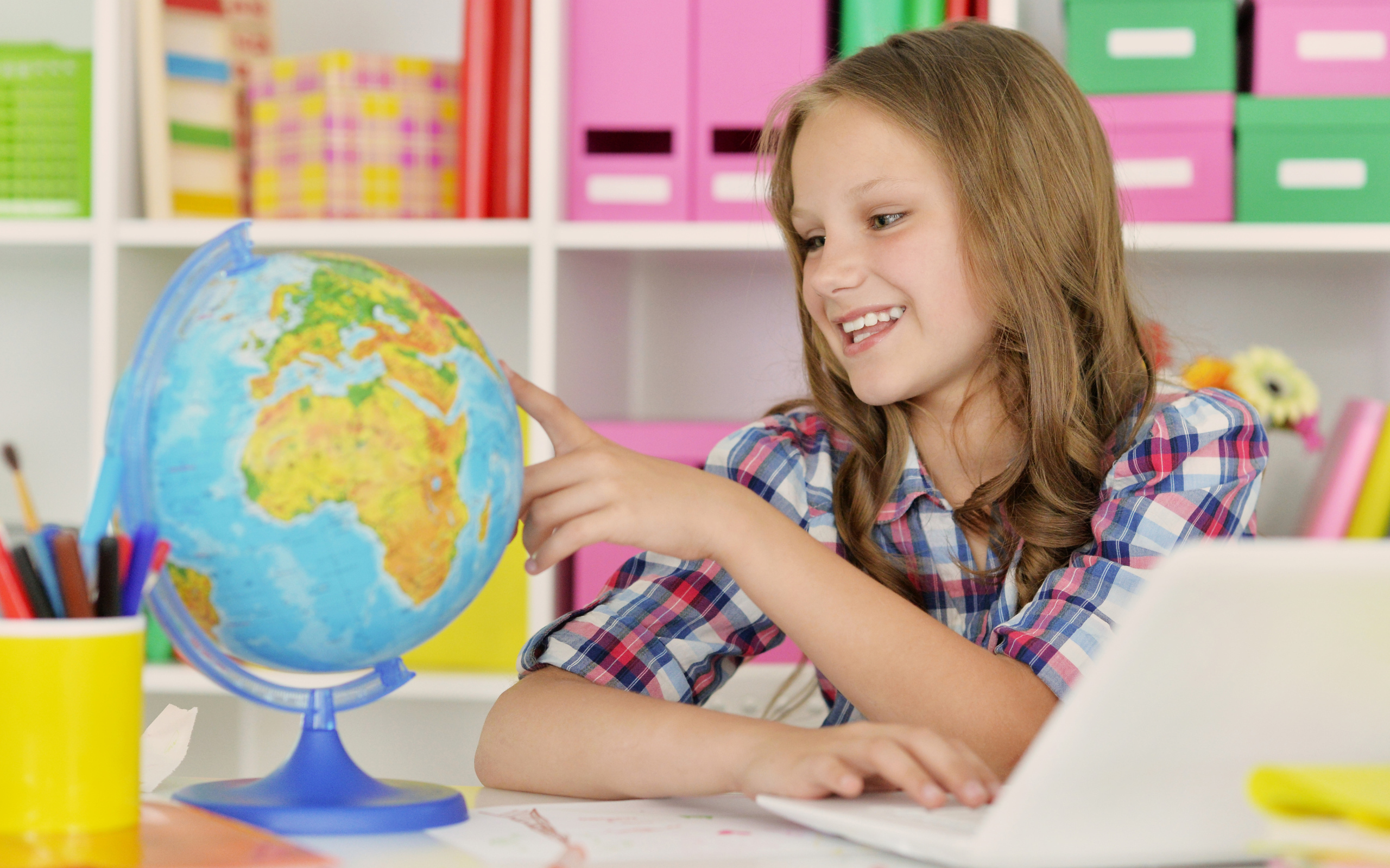 Улыбающаяся девочка школьница с глобусом