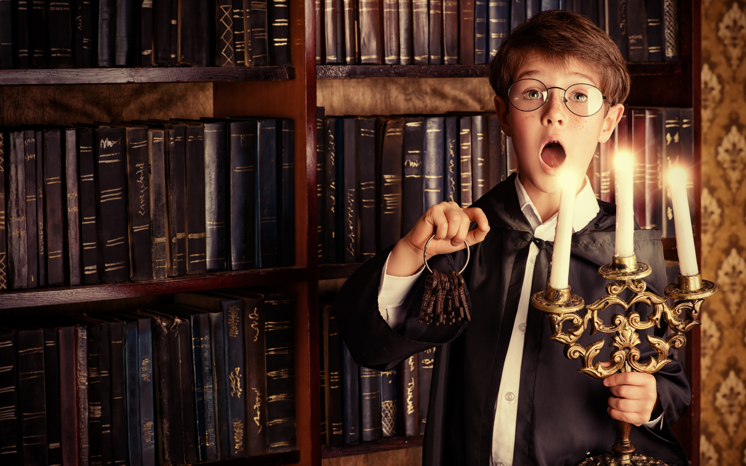 Удивленный мальчик с подсвечником со свечами в библиотеке