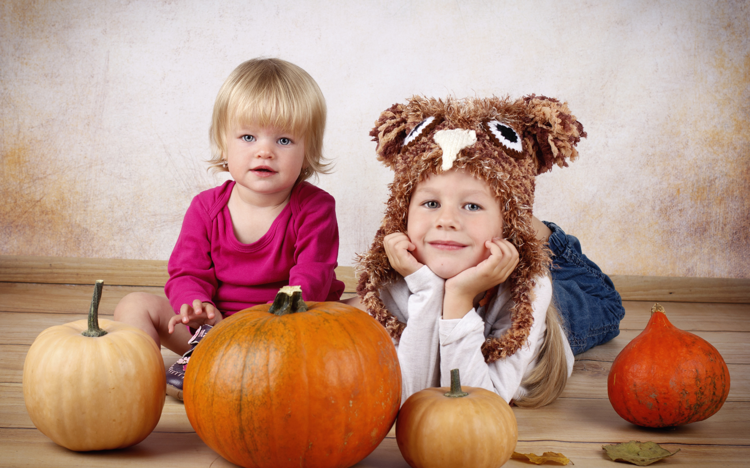 Два маленьких ребенка с тыквами в комнате