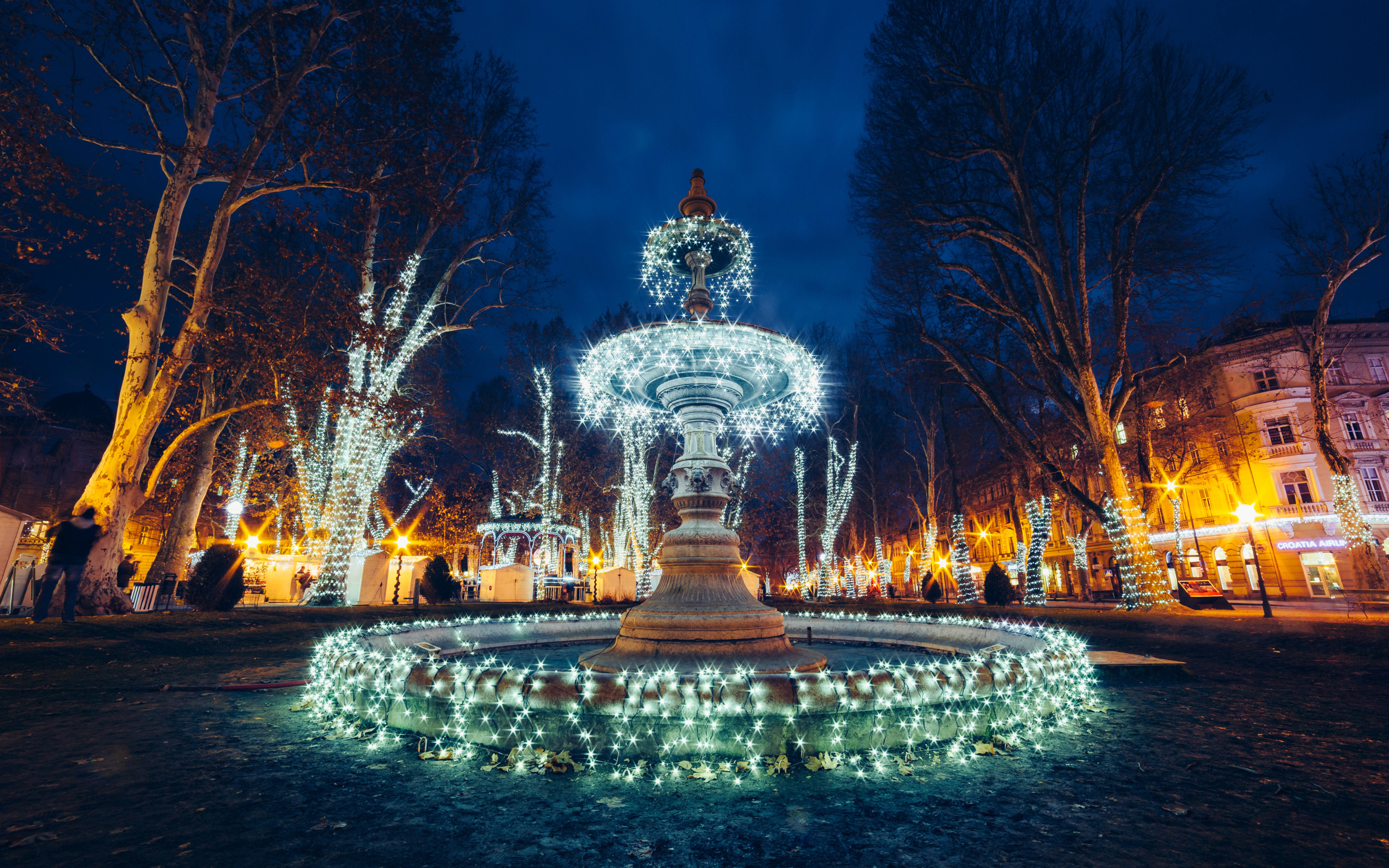 Красивый фонтан с гирляндами в городе вечером