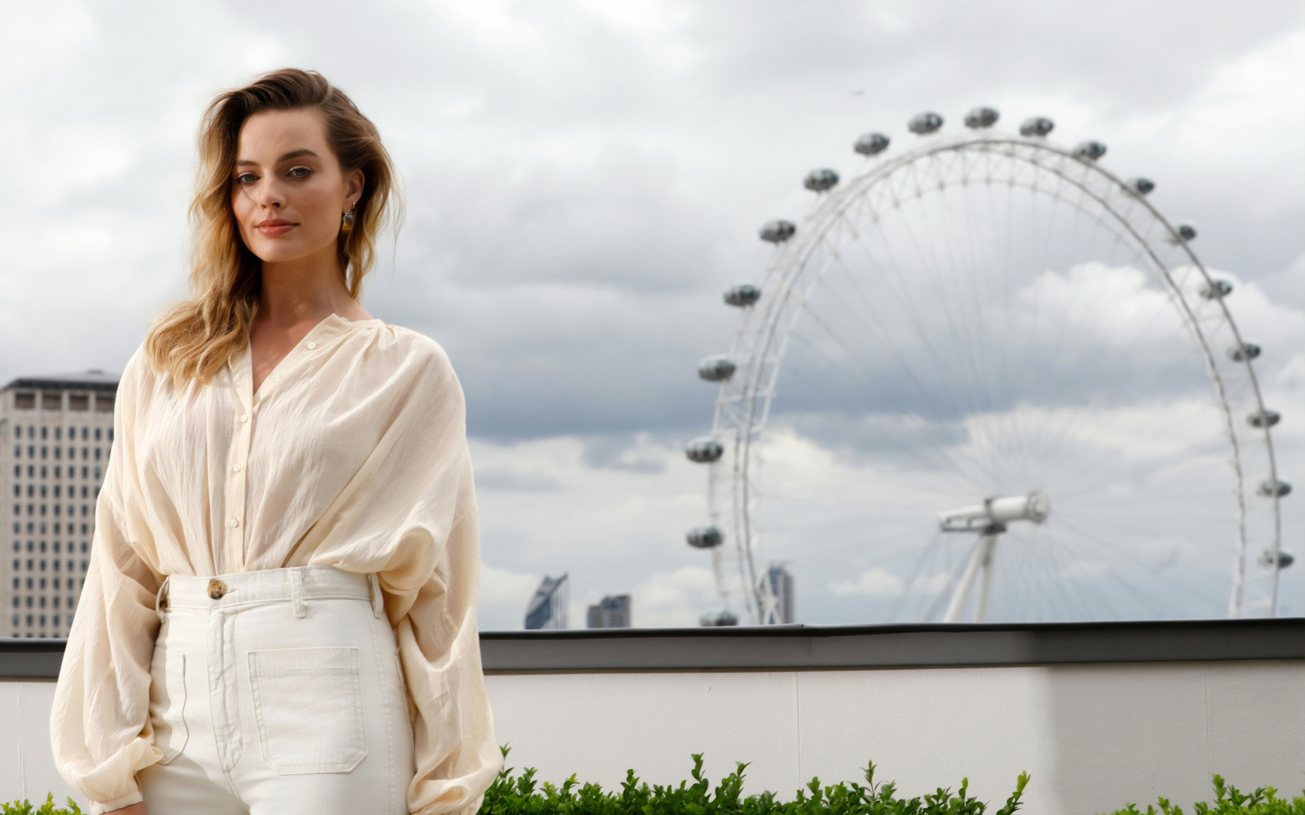 Актриса Марго Робби на  фоне аттракциона  колесо обозрения