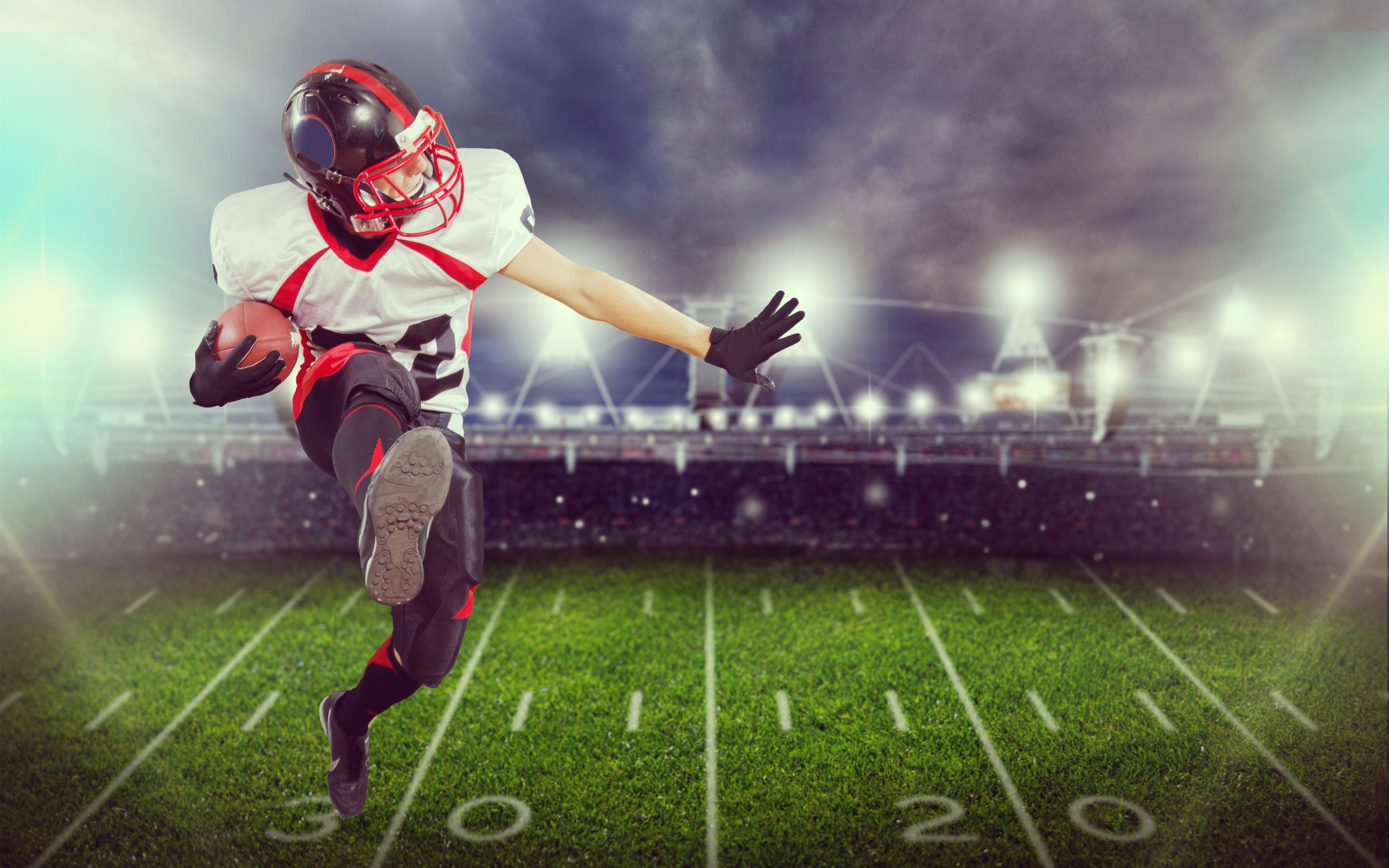 Игрок в американский футбол с мячом на поле