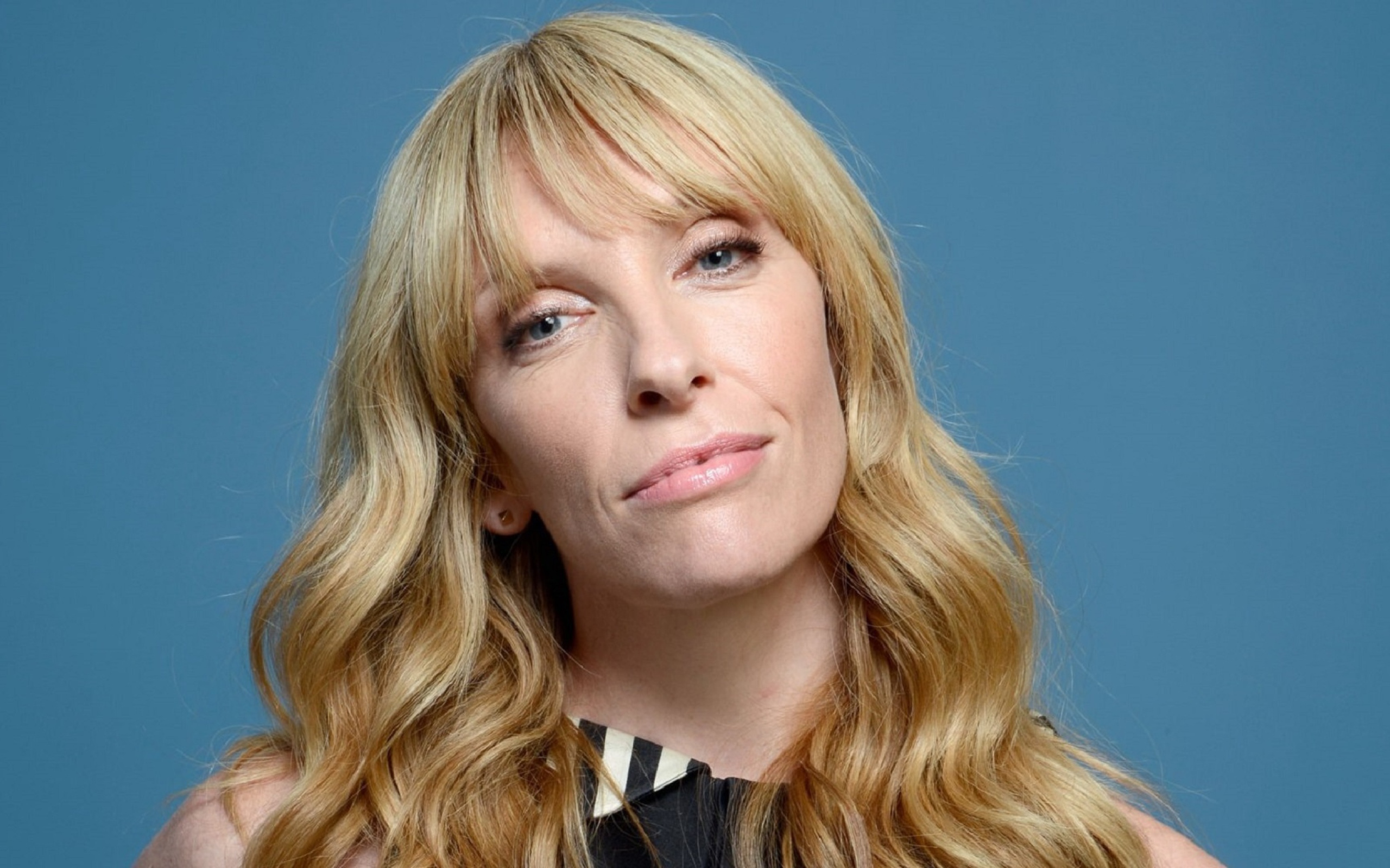 Голубоглазая блондинка, актриса Тони Коллетт на голубом фоне