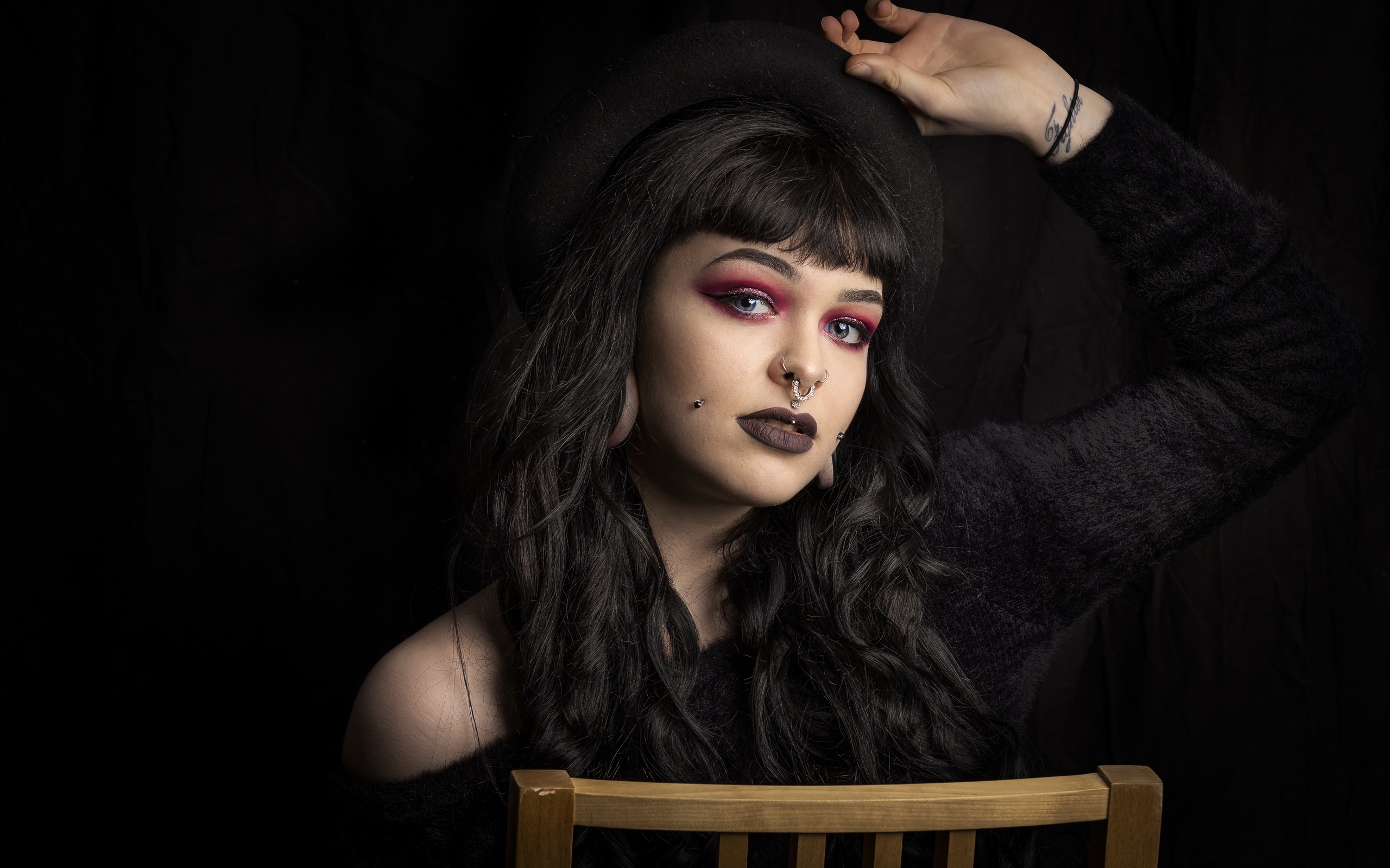 Девушка неформалка с черной шляпе с пирсингом на лице