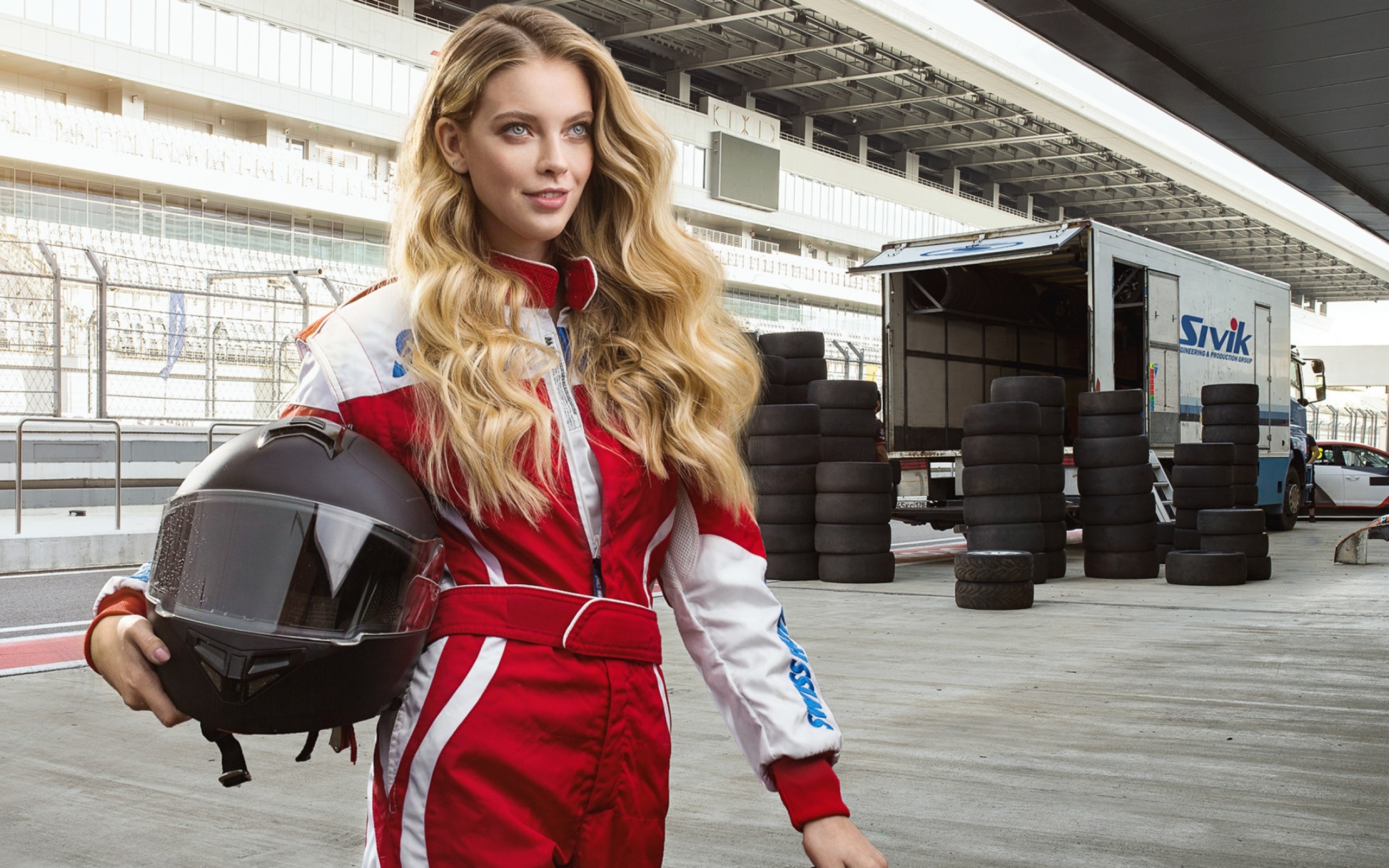 Девушка гонщица с шлемом в руках