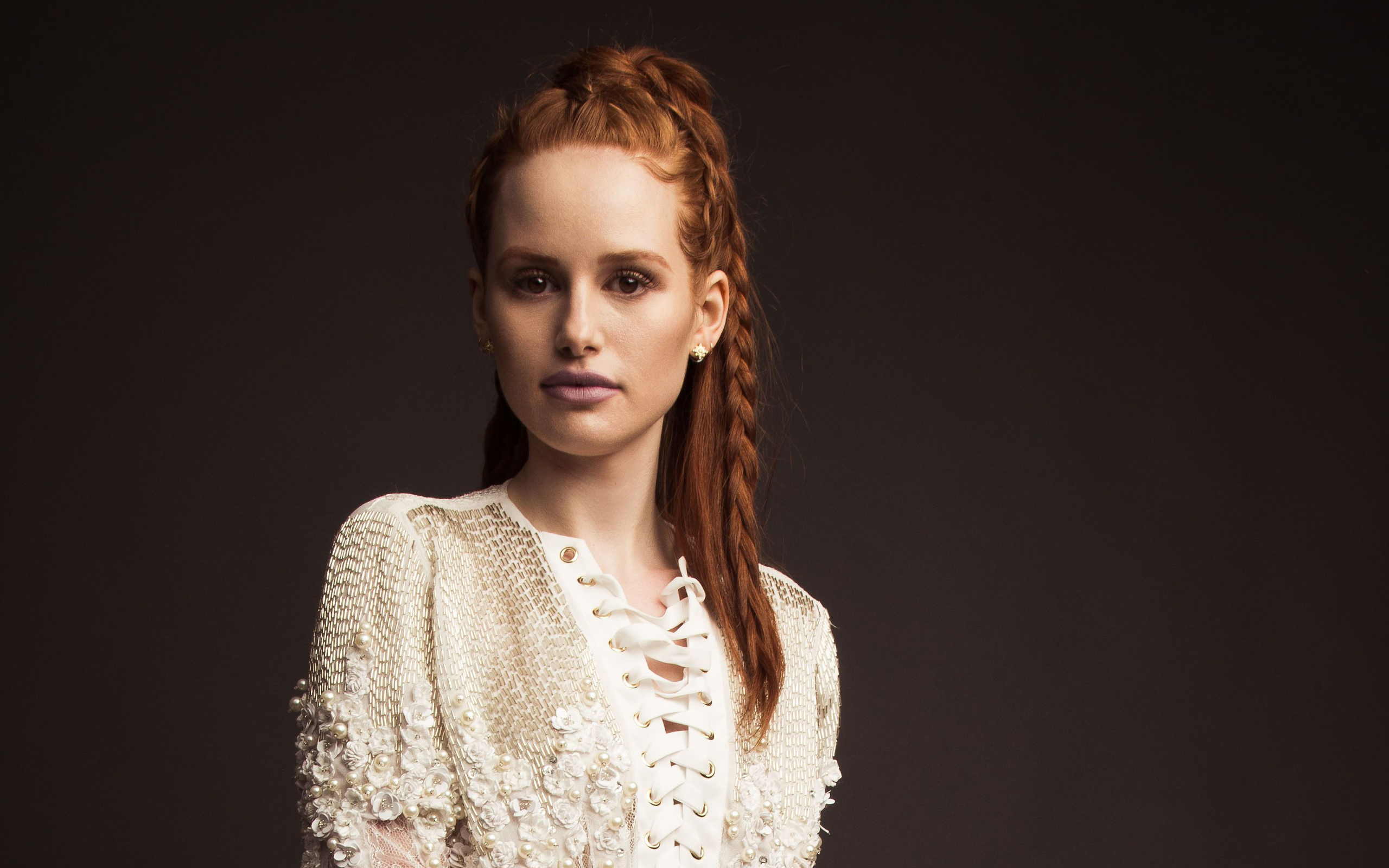 Рыжеволосая актриса Мэделин Петш в белом платье на сером фоне