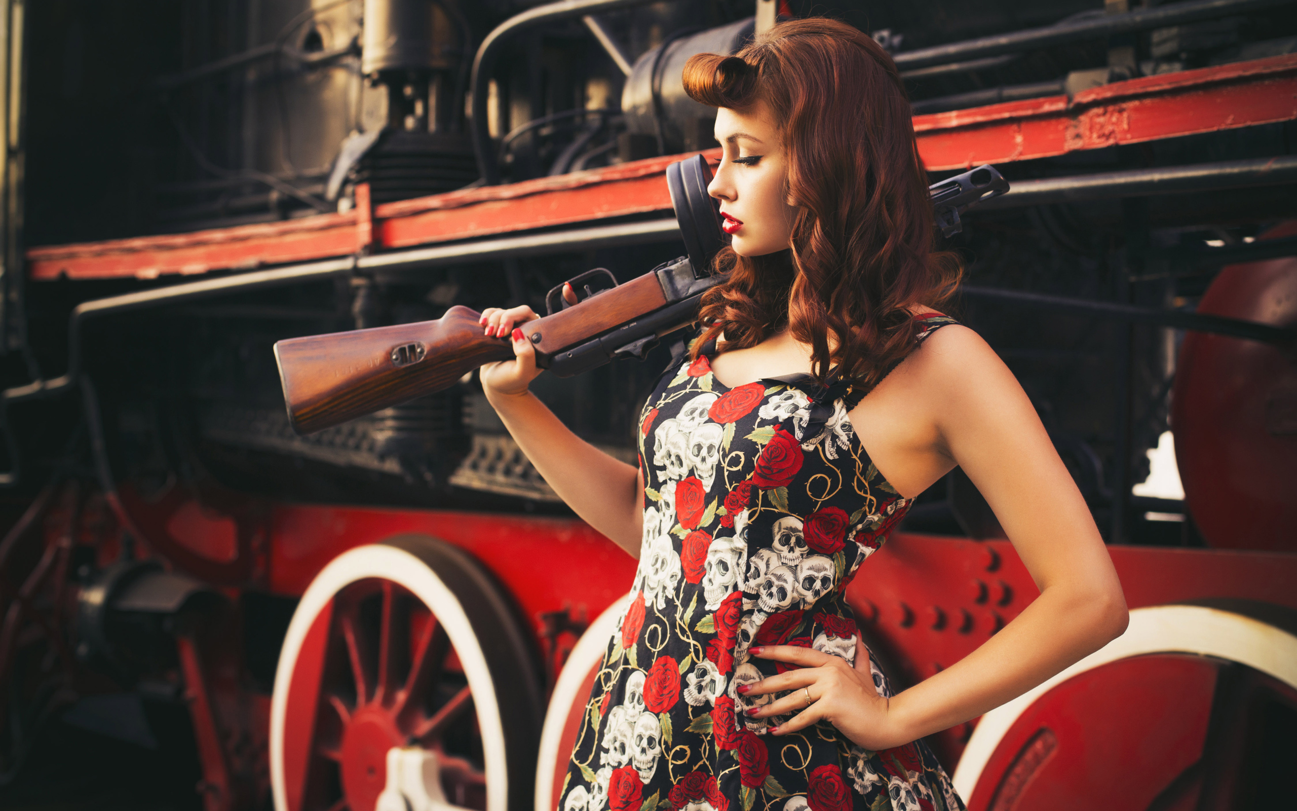 Retro girl with a gun in the hand of a diesel locomotive  