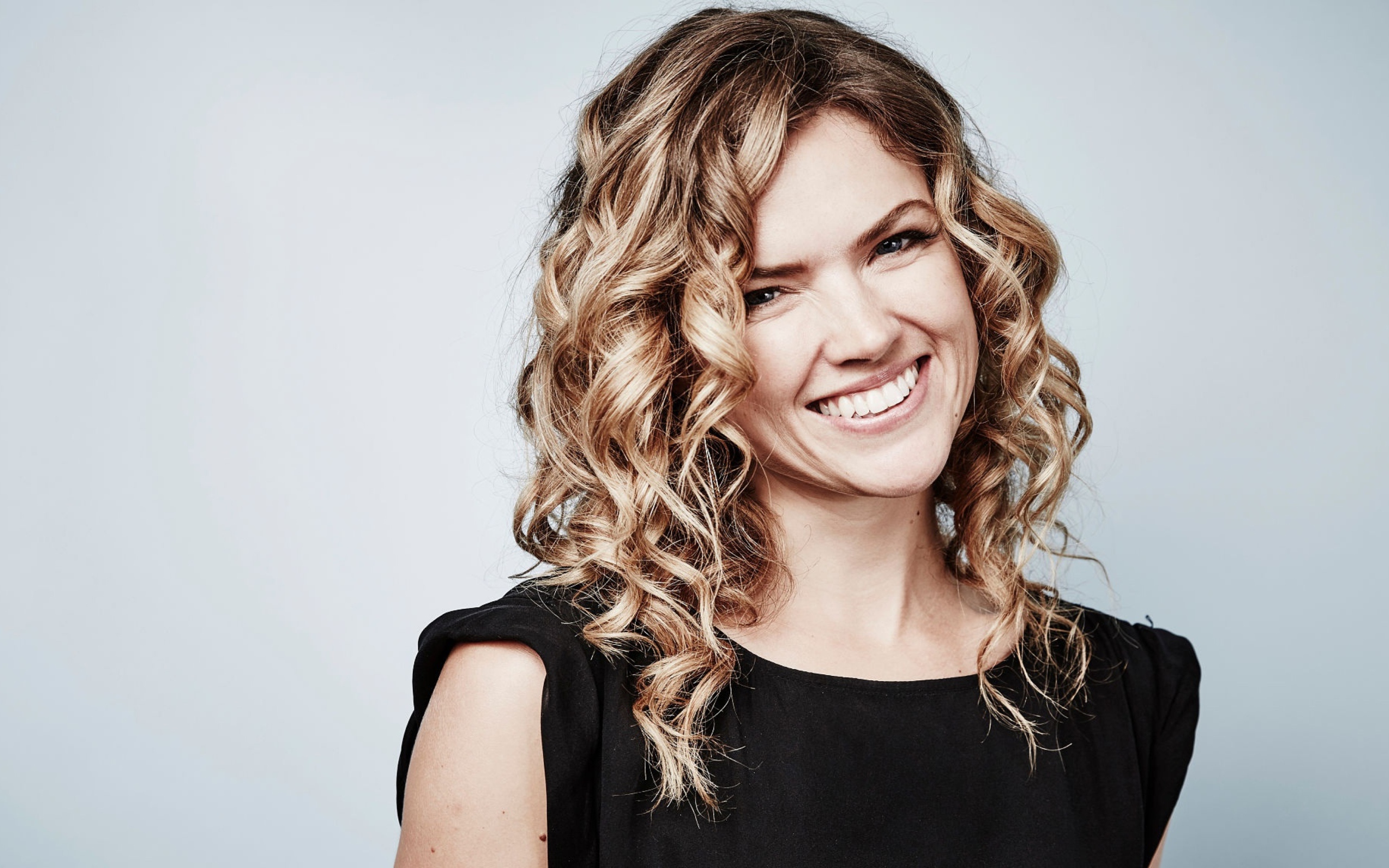 Улыбающаяся блондинка, актриса Эрин Ричардс на сером фоне