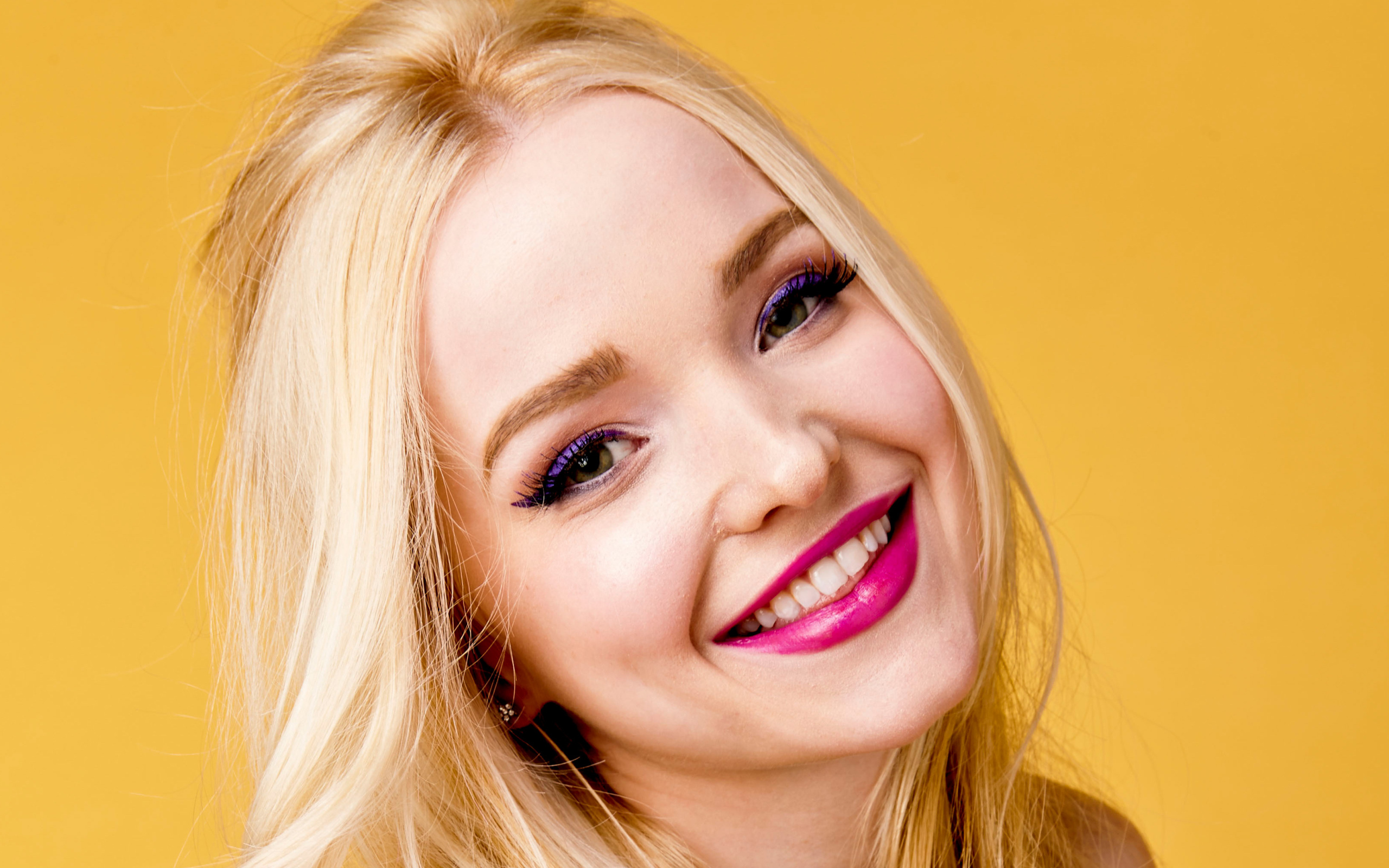 Улыбающаяся девушка актриса Дав Кэрон на желтом фоне крупным планом