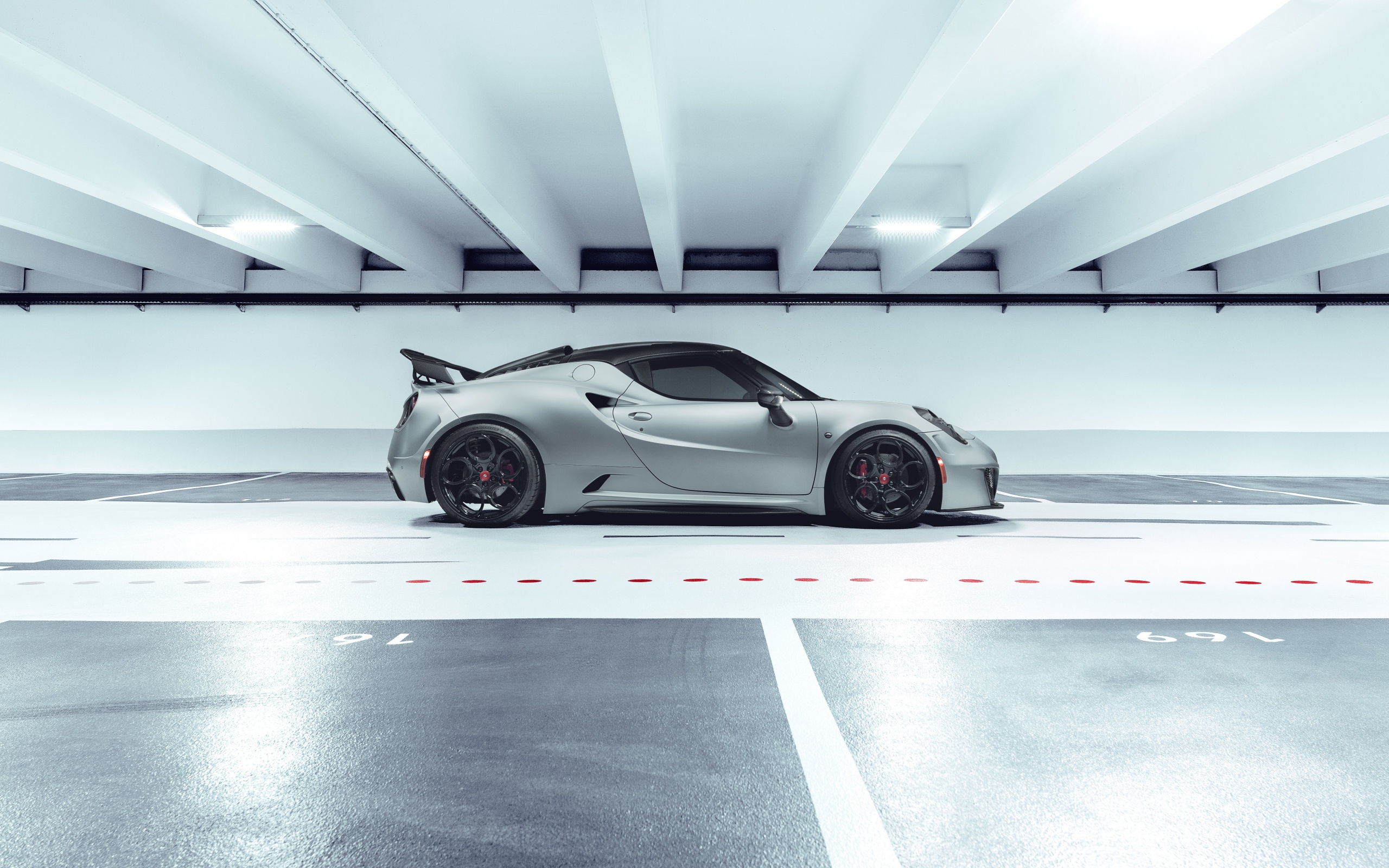 Серый автомобиль Pogea Racing Nemesis 2020 года на парковке 