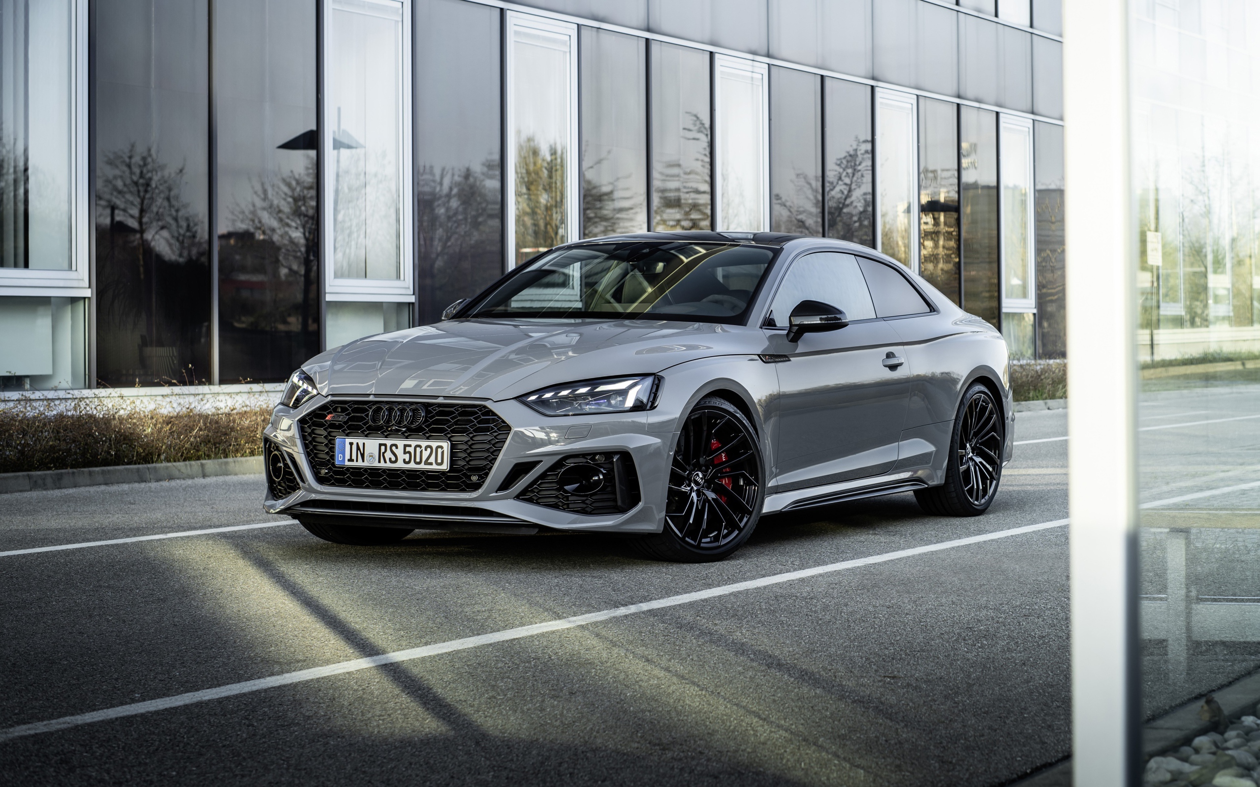Серебристый автомобиль Audi RS 5 Coupe у здания 