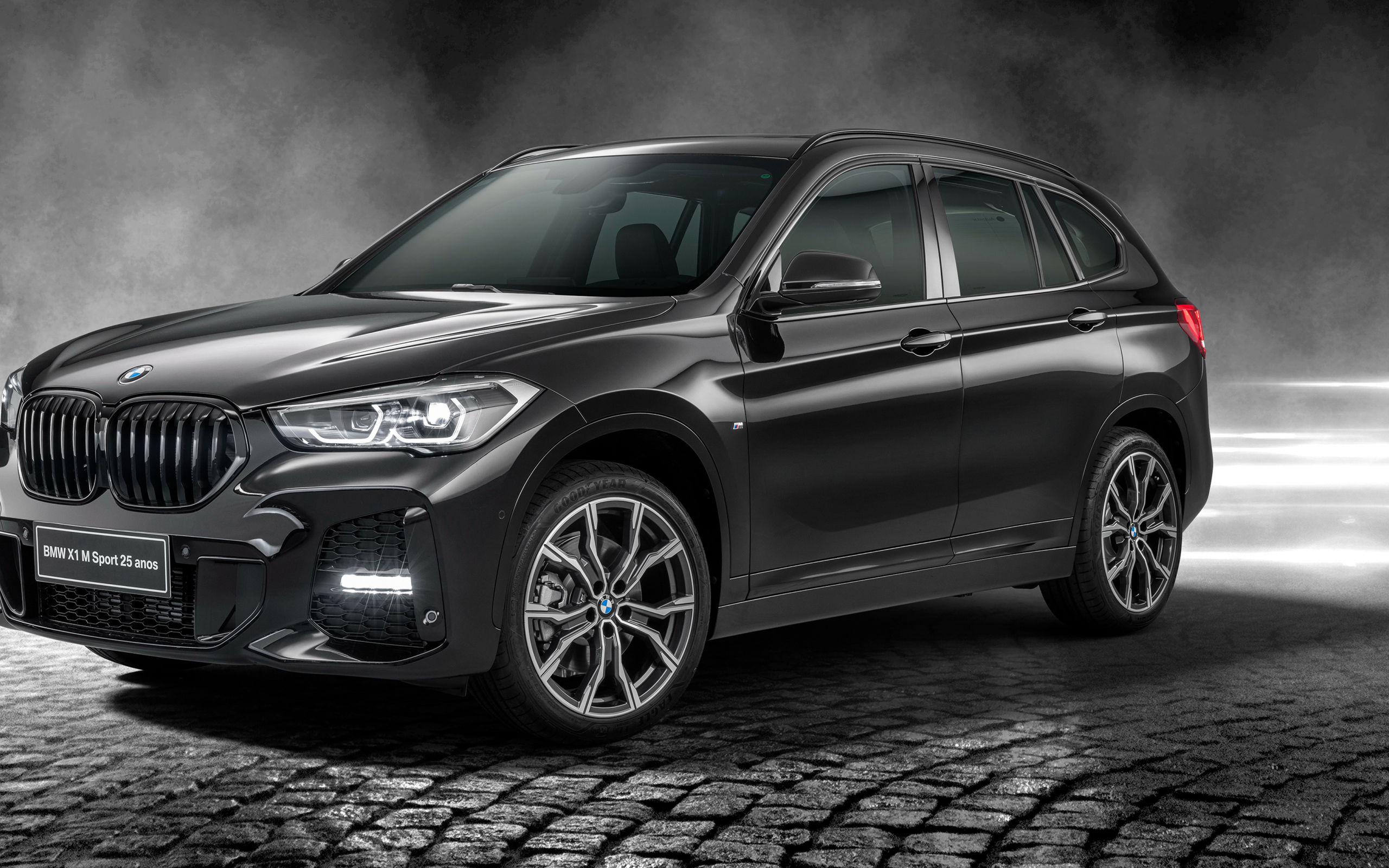 Черный автомобиль BMW X1 SDrive20i M Sport 25 Anos 2020 года в свете софитов