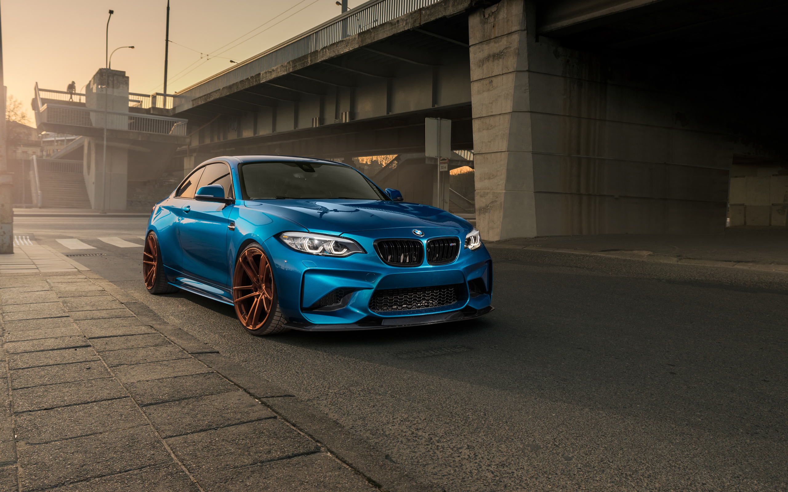 Синий автомобиль BMW M2 у моста 
