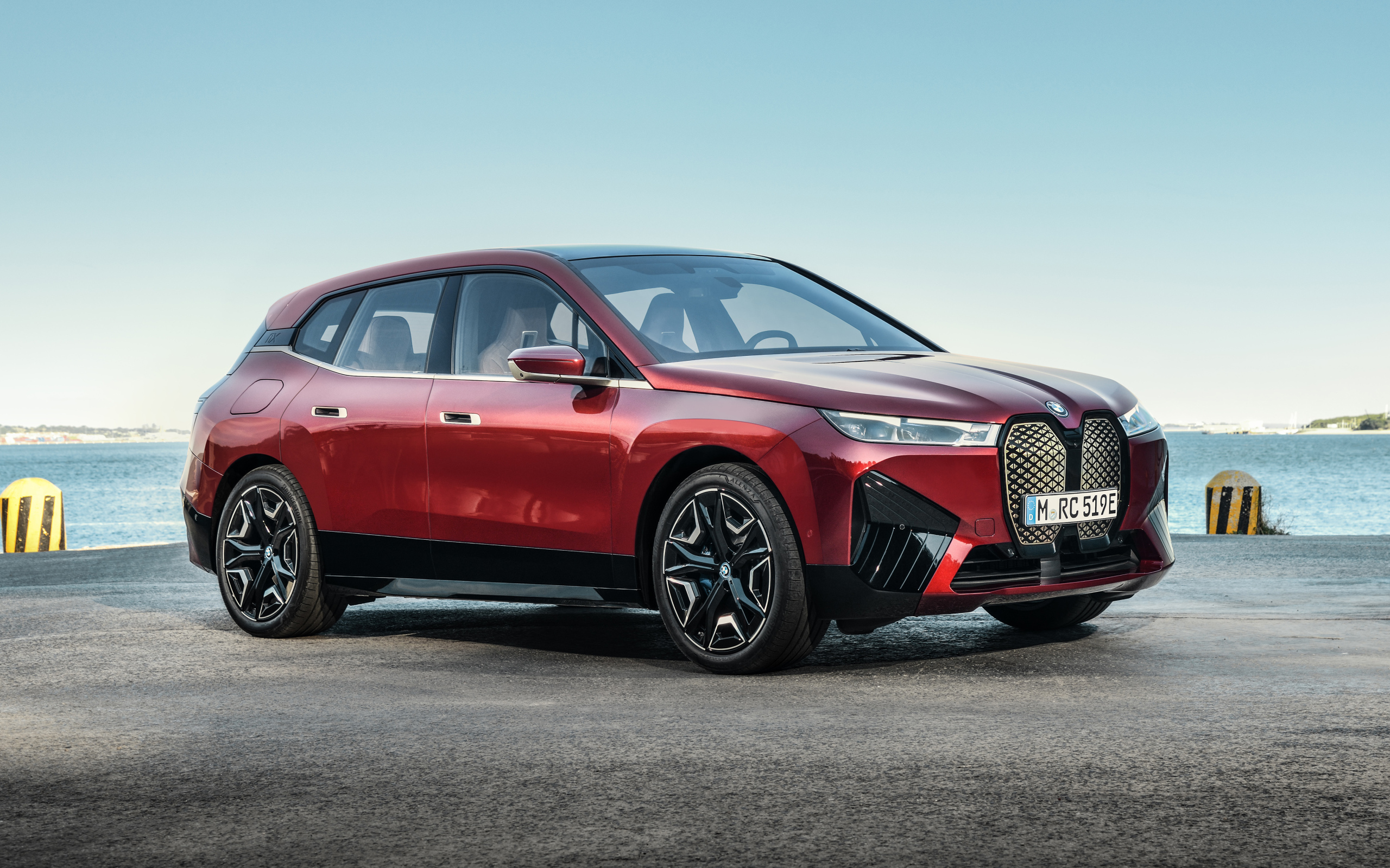 Бордовый автомобиль BMW IX 2021 года у воды