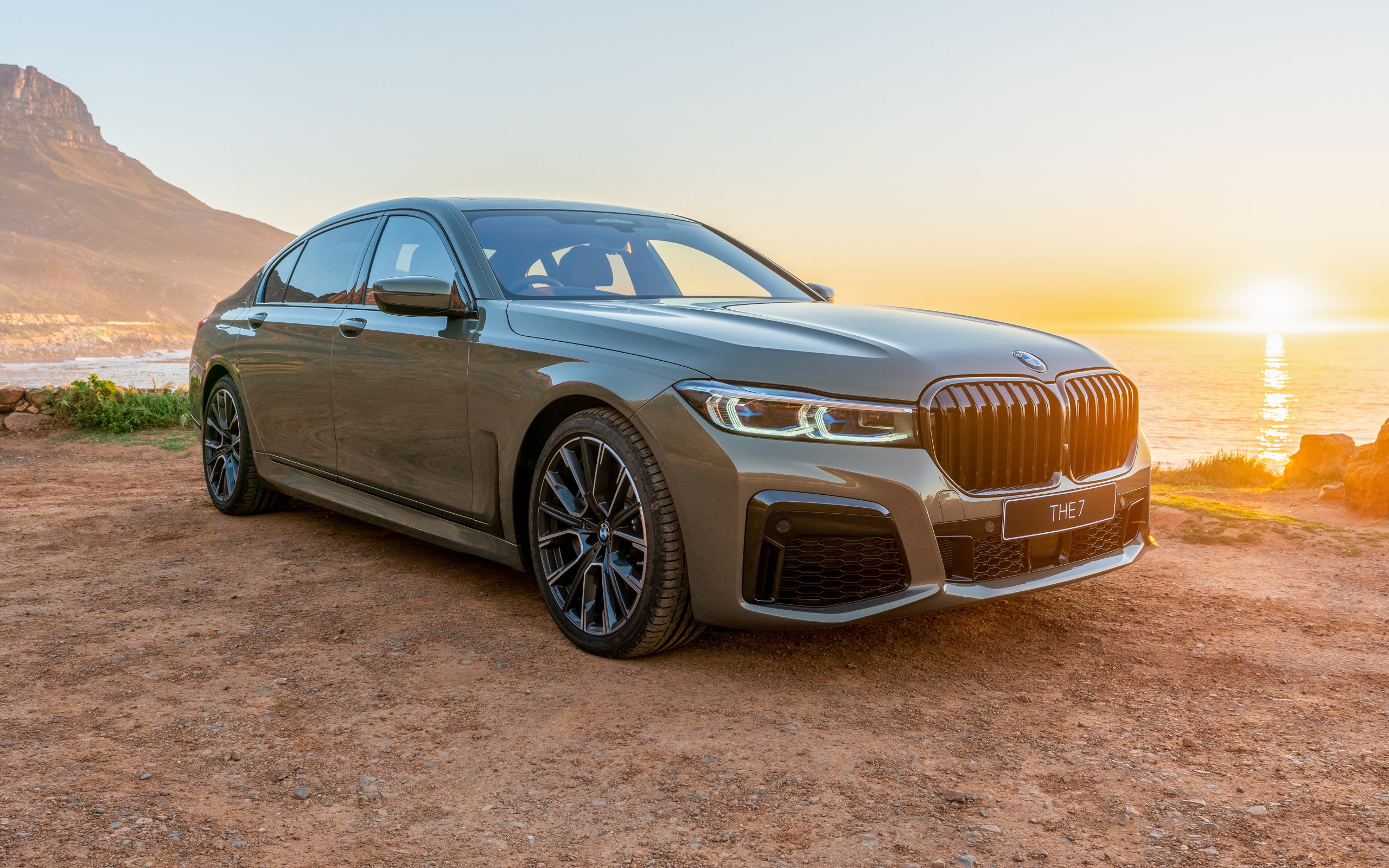 Стильный дорогой автомобиль BMW 745Le , 2020 года на фоне заката