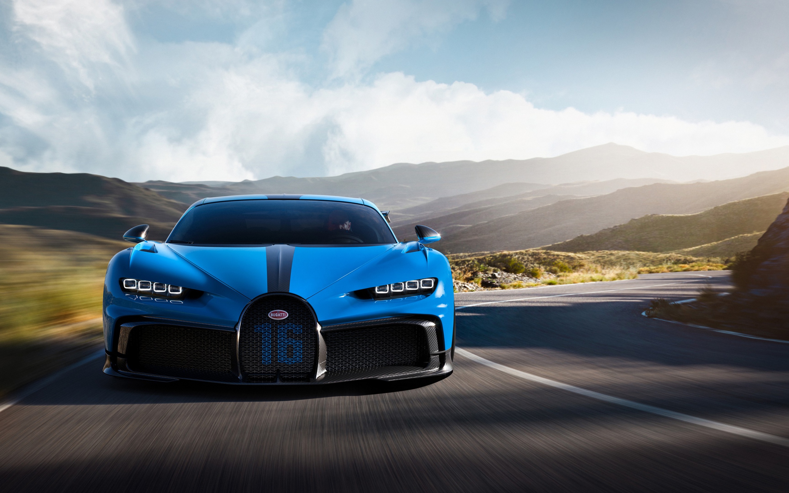 Синий автомобиль Bugatti Chiron Pur Sport 2020 года на трассе в горах 